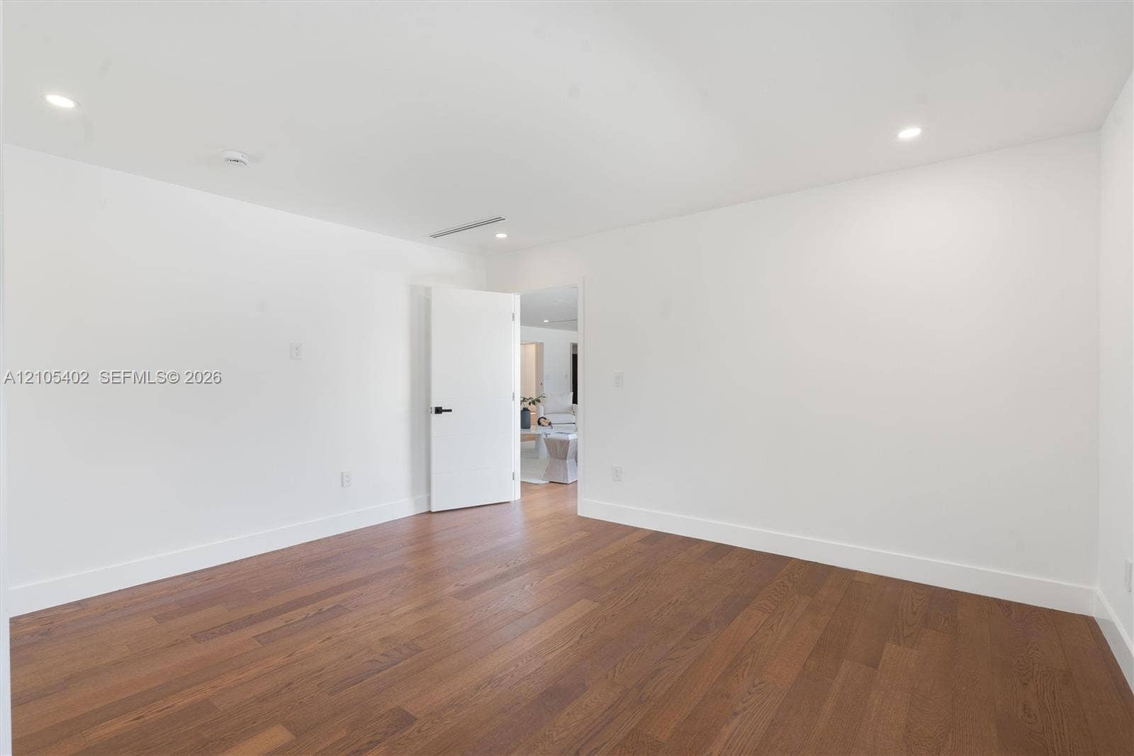 1911 SW 18th Avenue, Miami, FL 33145 Interior room featuring wood-finish flooring, recessed lighting, and a white interior door with matte black hardware
