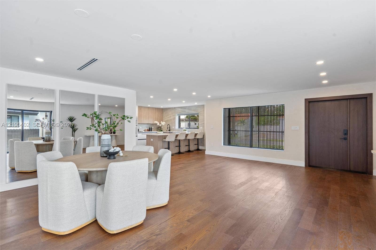 1911 SW 18th Avenue, Miami, FL 33145 Open-concept interior featuring wood-finish flooring, recessed lighting, a built-in wall mirror, and a solid wood front door