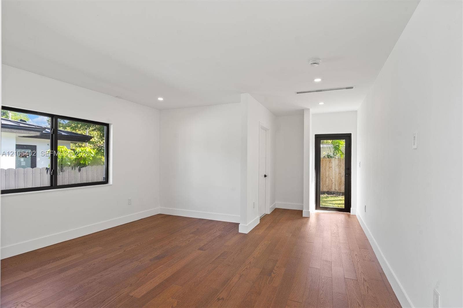 1911 SW 18th Avenue, Miami, FL 33145 Interior space featuring wood-finish flooring, recessed lighting, and a glass-paneled exterior door with black framing