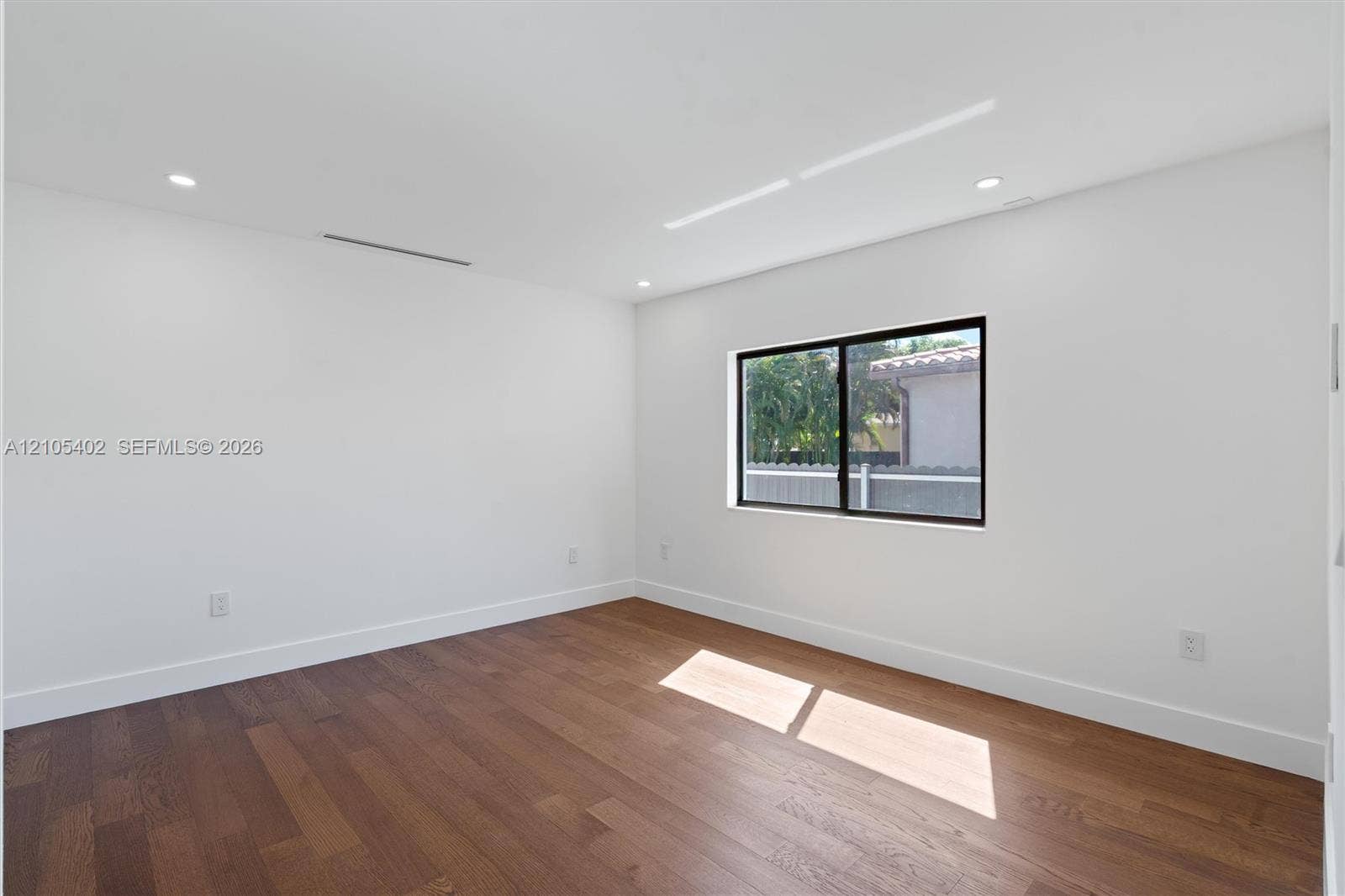 1911 SW 18th Avenue, Miami, FL 33145 Interior space featuring wood-finish flooring, recessed lighting, and a single-pane window with a black frame