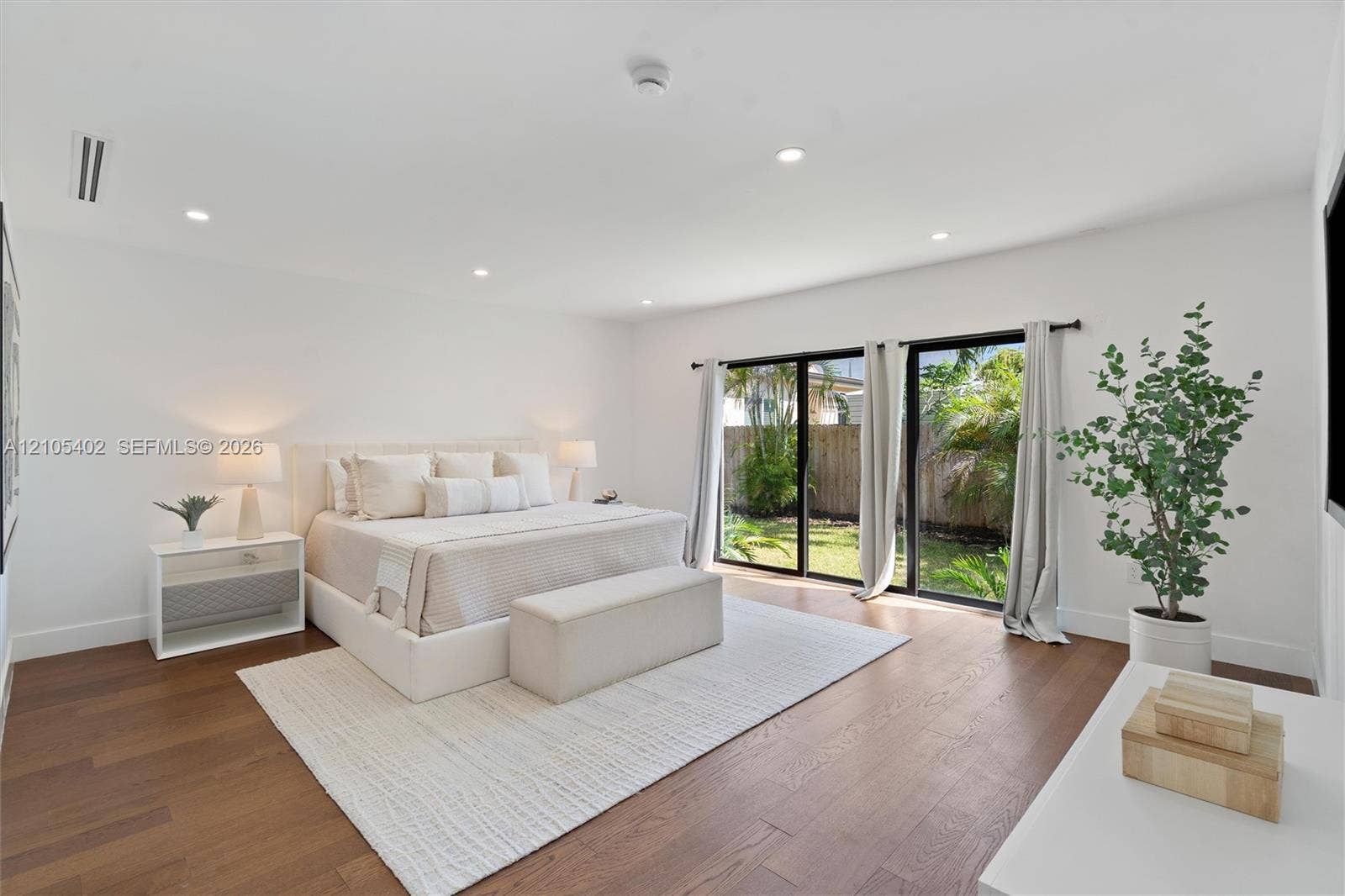 1911 SW 18th Avenue, Miami, FL 33145 Wide room featuring wood-finish flooring, recessed lighting, and expansive black-framed glass sliding doors opening to exterior grounds