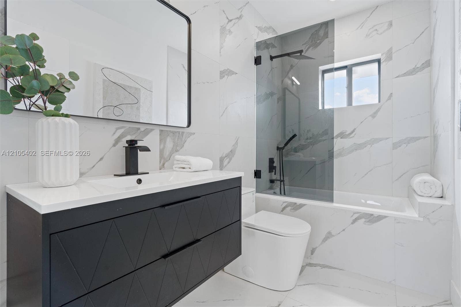 1911 SW 18th Avenue, Miami, FL 33145 Modern floating vanity with a matte black geometric-patterned finish, white countertop, and black faucet