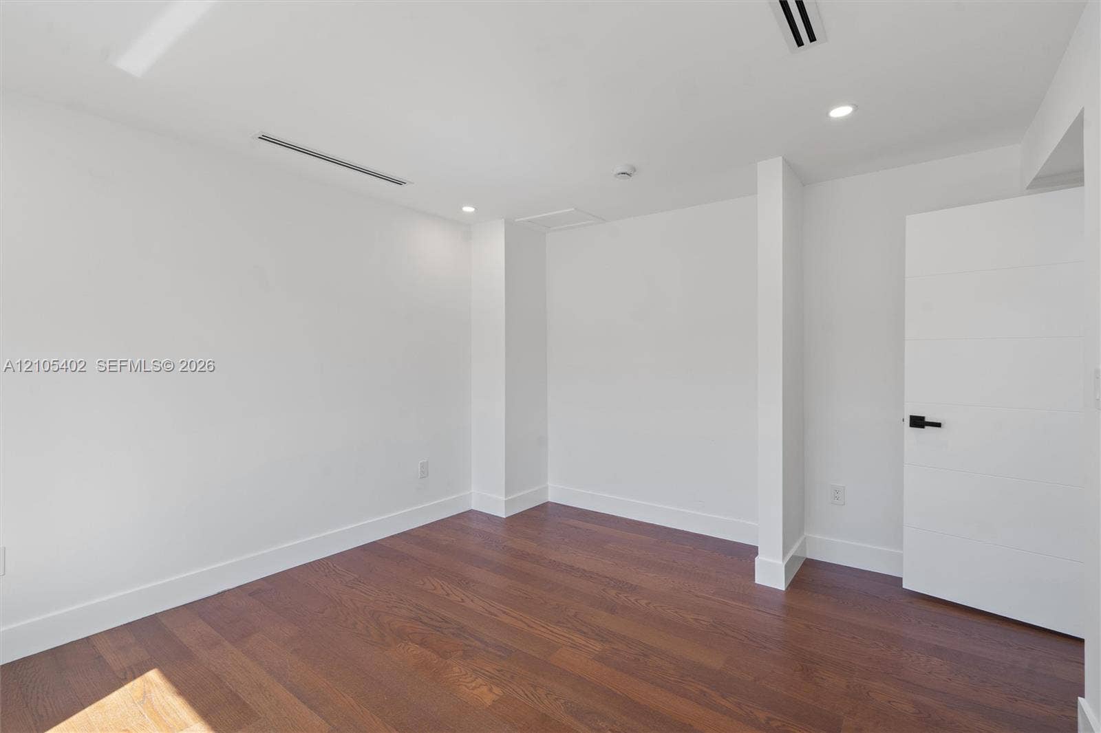1911 SW 18th Avenue, Miami, FL 33145 Neutral interior featuring wood-finish flooring, recessed lighting, and a multi-panel door with matte black hardware