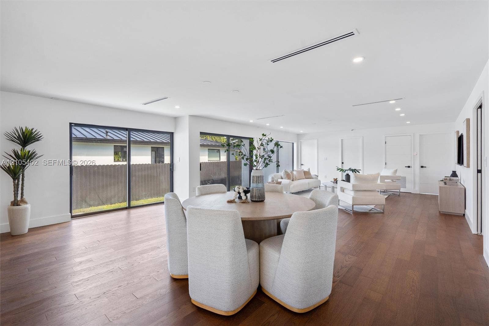 1911 SW 18th Avenue, Miami, FL 33145 Open-concept interior featuring wood-finish flooring, recessed lighting, and multiple oversized sliding glass doors