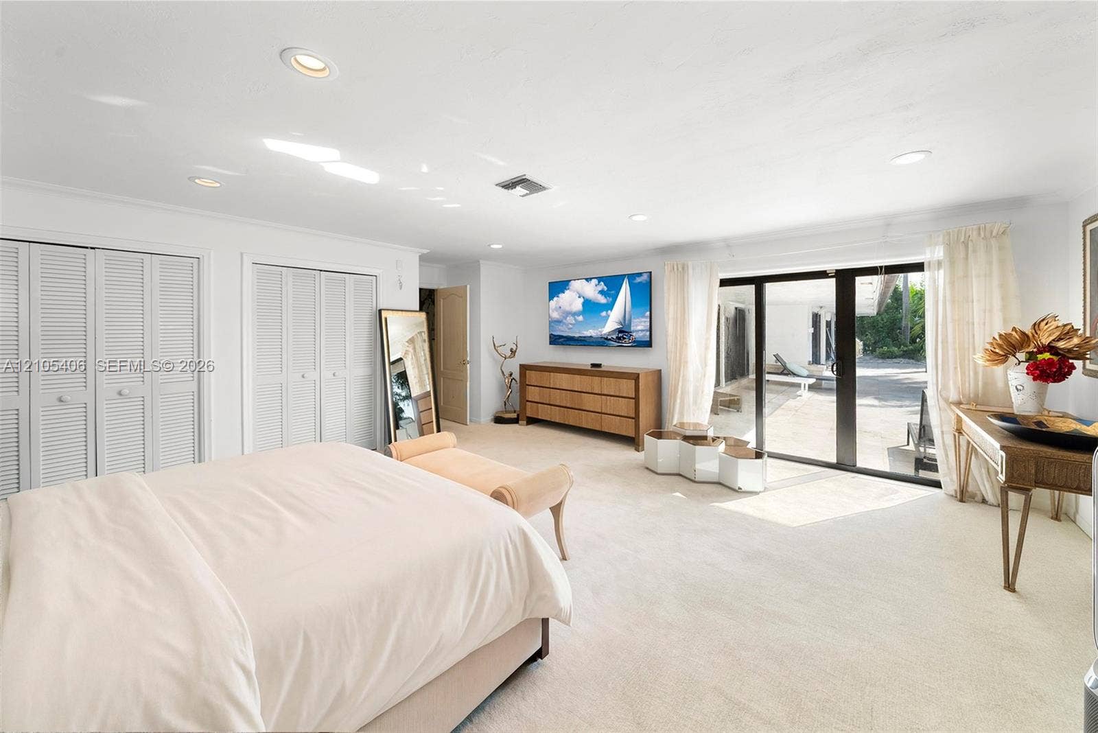 Wall-to-wall carpeting, recessed lighting, louvered closet doors, and direct outdoor access through glass sliding doors