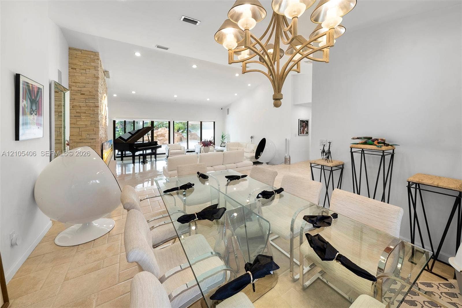 Open-concept living space with tiled flooring, a stone accent wall, and recessed lighting