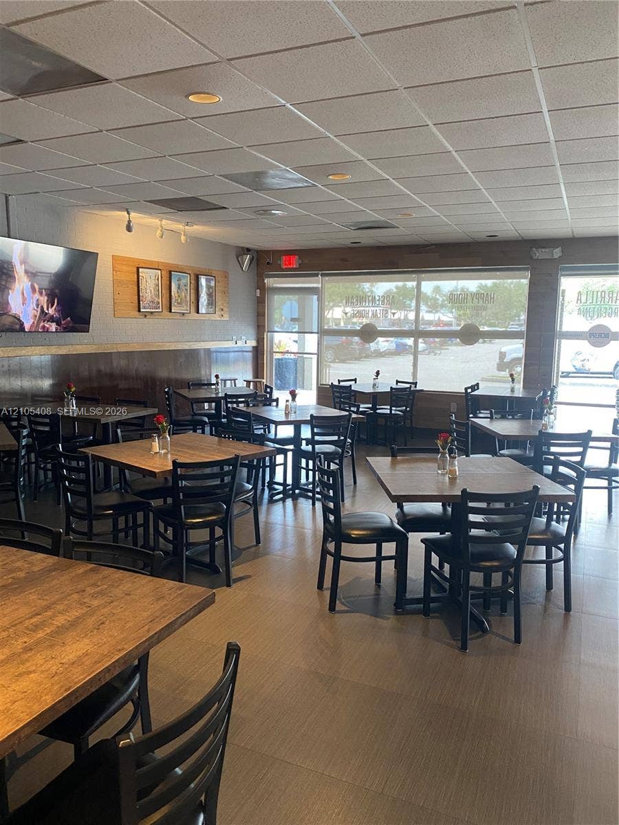 Recessed lighting, wood-finish flooring, drop ceiling, large storefront windows, and wood-paneled accents