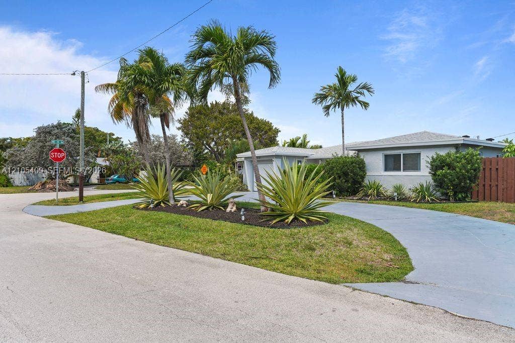 Single-story residence with a light-colored exterior, an attached garage, and a paved driveway