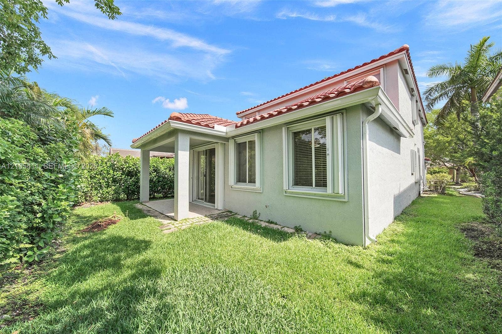 Exterior featuring a covered patio, stucco siding, and a red tile roof