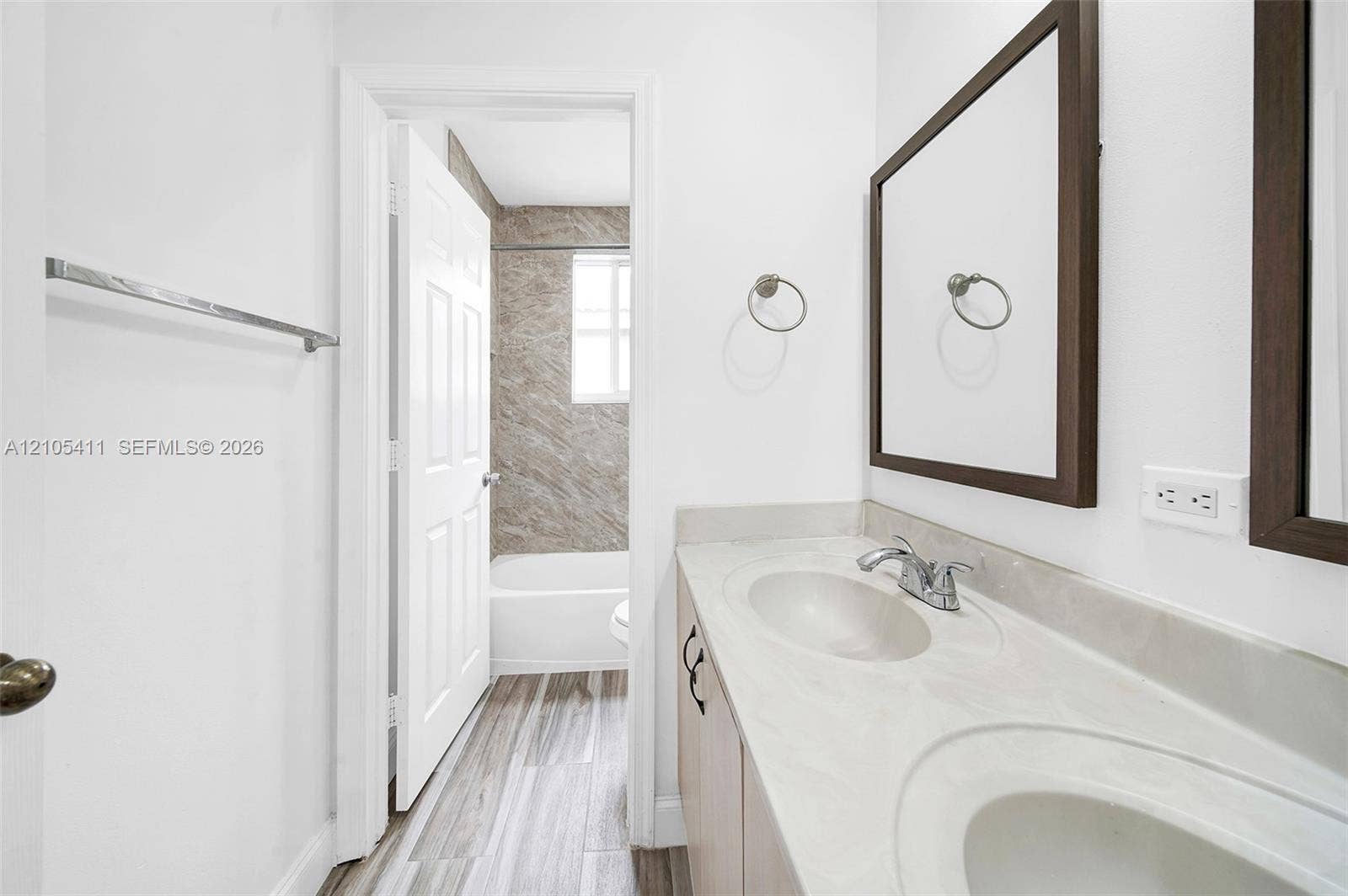Double vanity with integrated sinks, framed mirrors, and wood-finish cabinetry