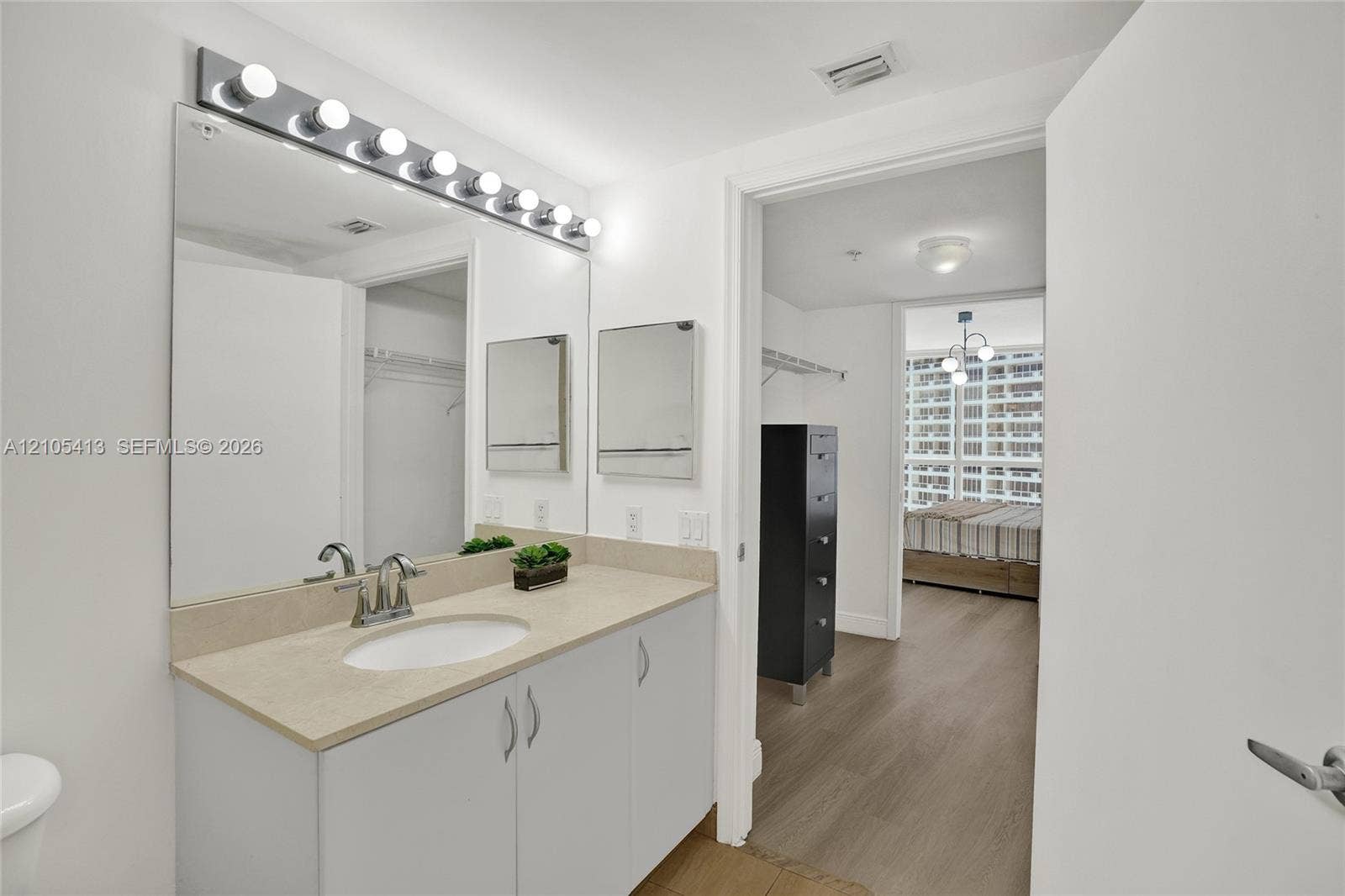 Vanity with a single basin, light-toned countertop, and integrated storage cabinetry