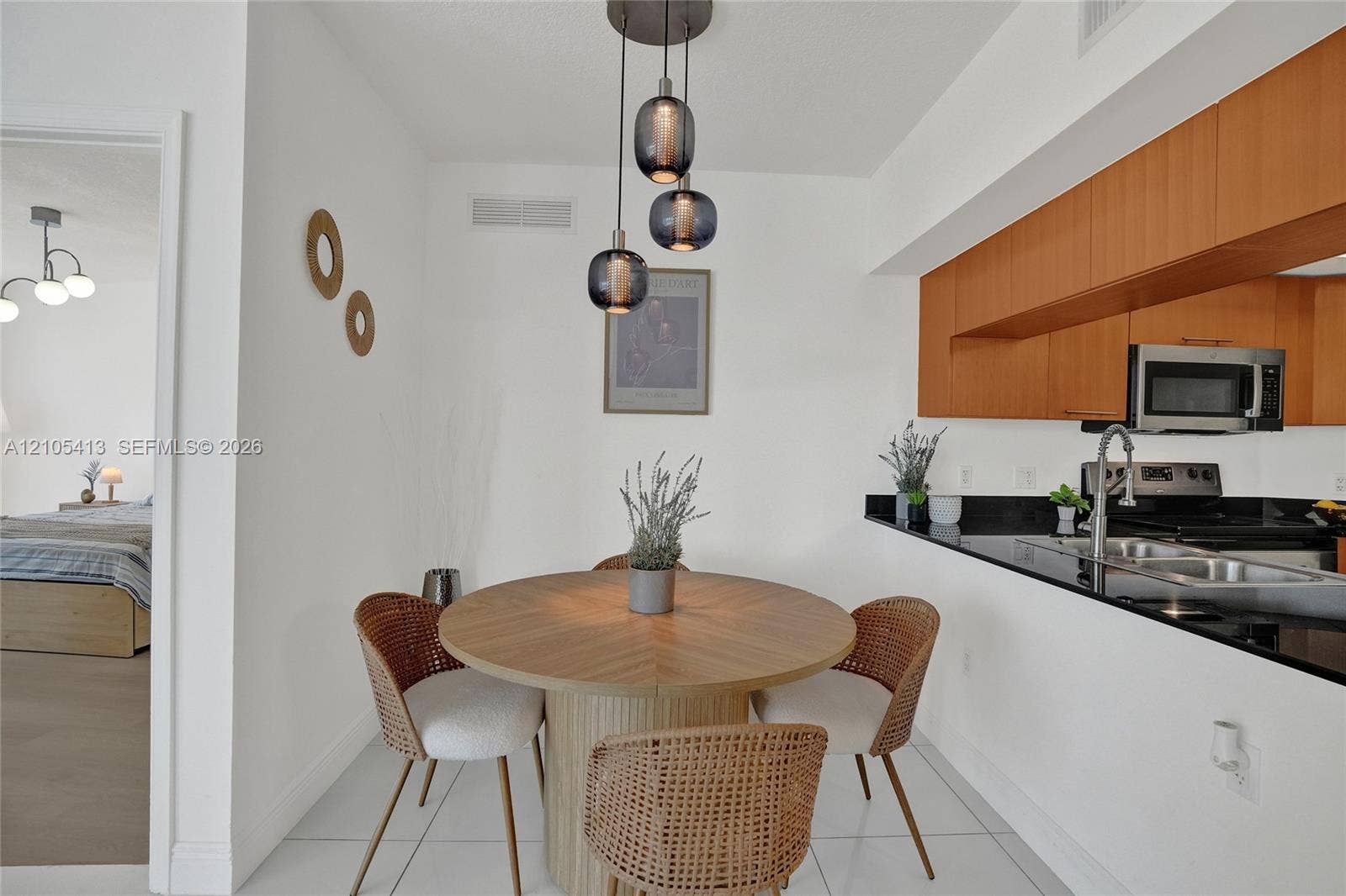 Modern pendant lighting over a dining area with white tile flooring