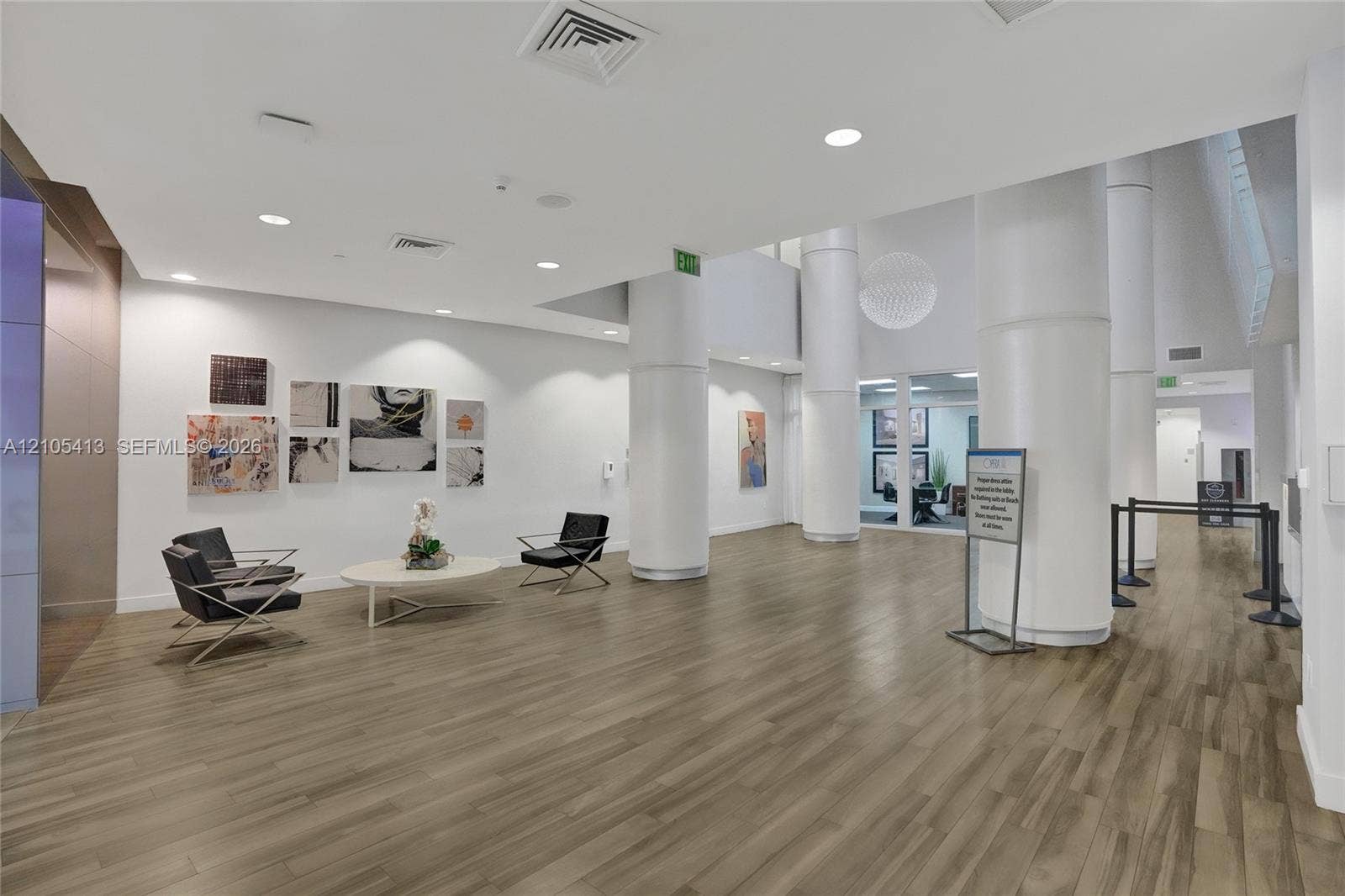 Spacious common area featuring wood-finish flooring, recessed lighting, and white support columns