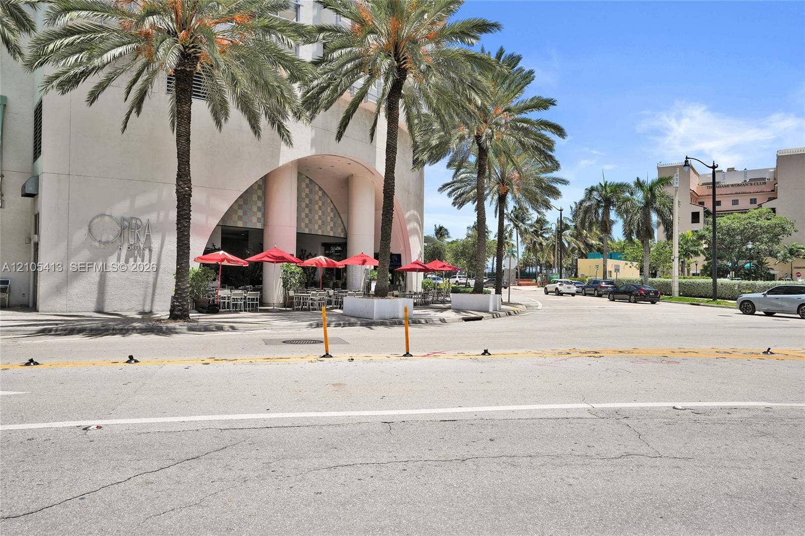 Striking mid-century modern architecture anchors this streetfront property, featuring a curved archway entrance with geometric detailing and clean-lined facade