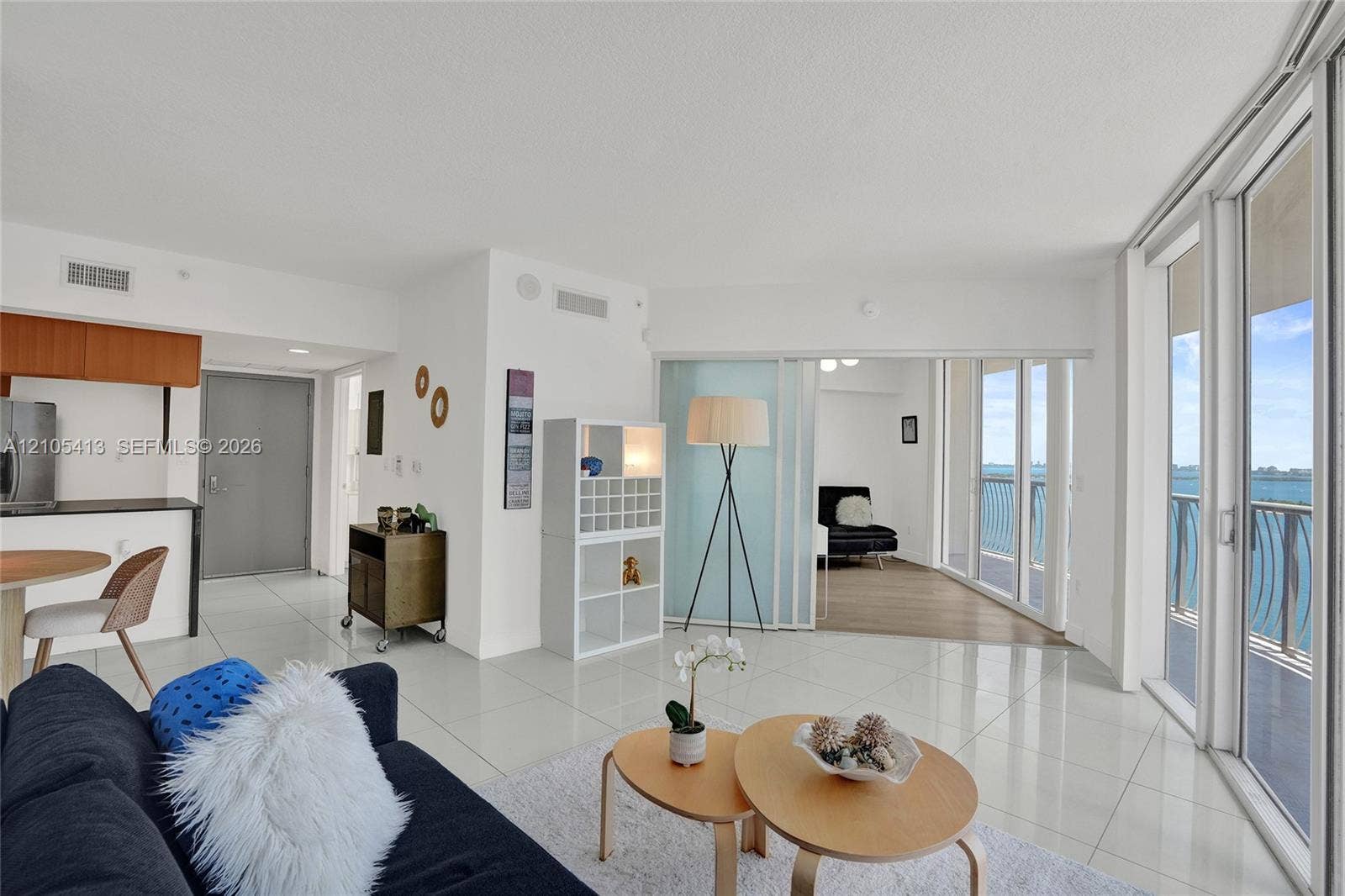 Expansive floor-to-ceiling glass sliding doors, glossy tile flooring, and integrated wall shelving