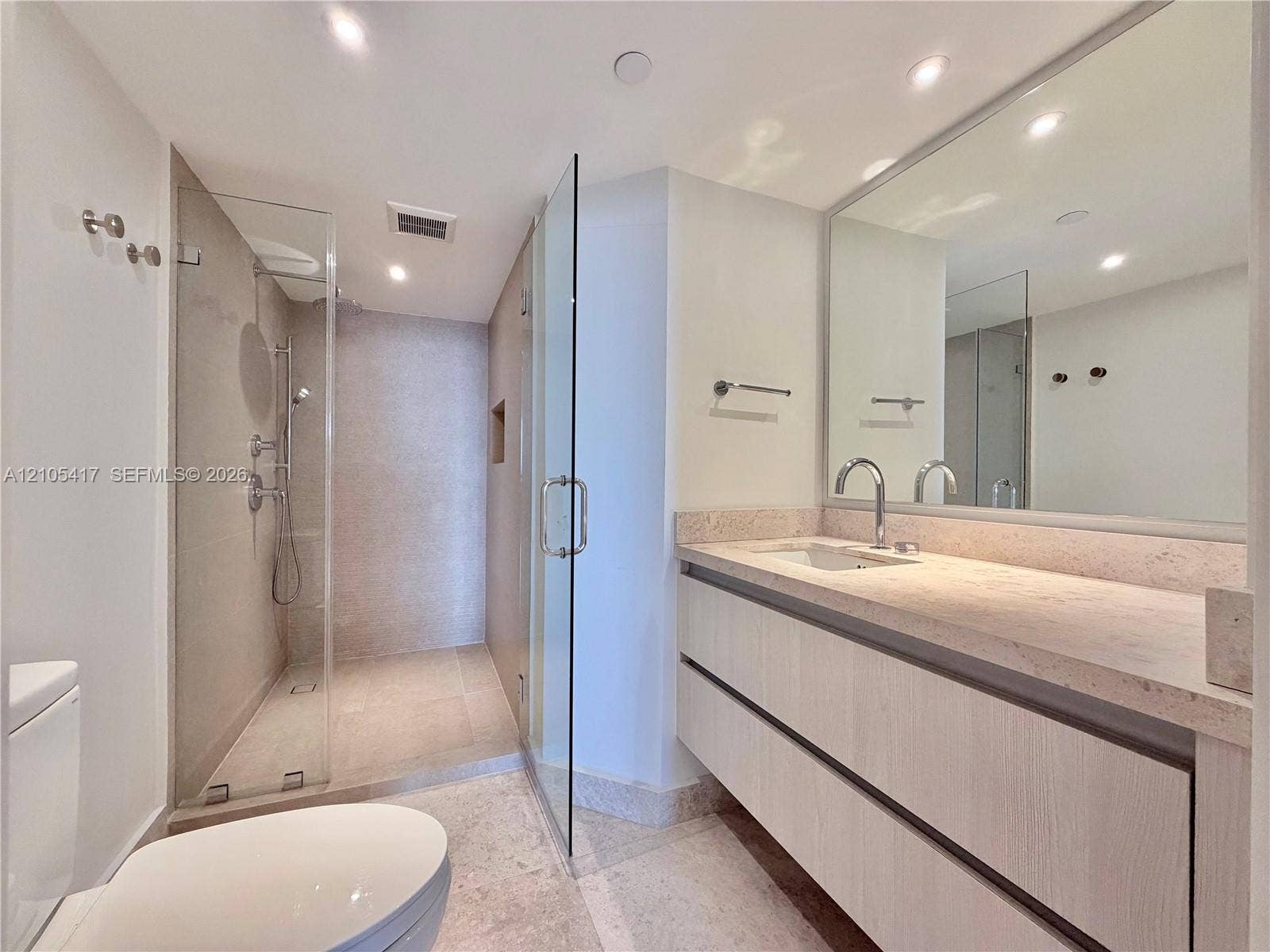 Floating vanity with a light-toned countertop, under-mount sink, and contemporary faucet