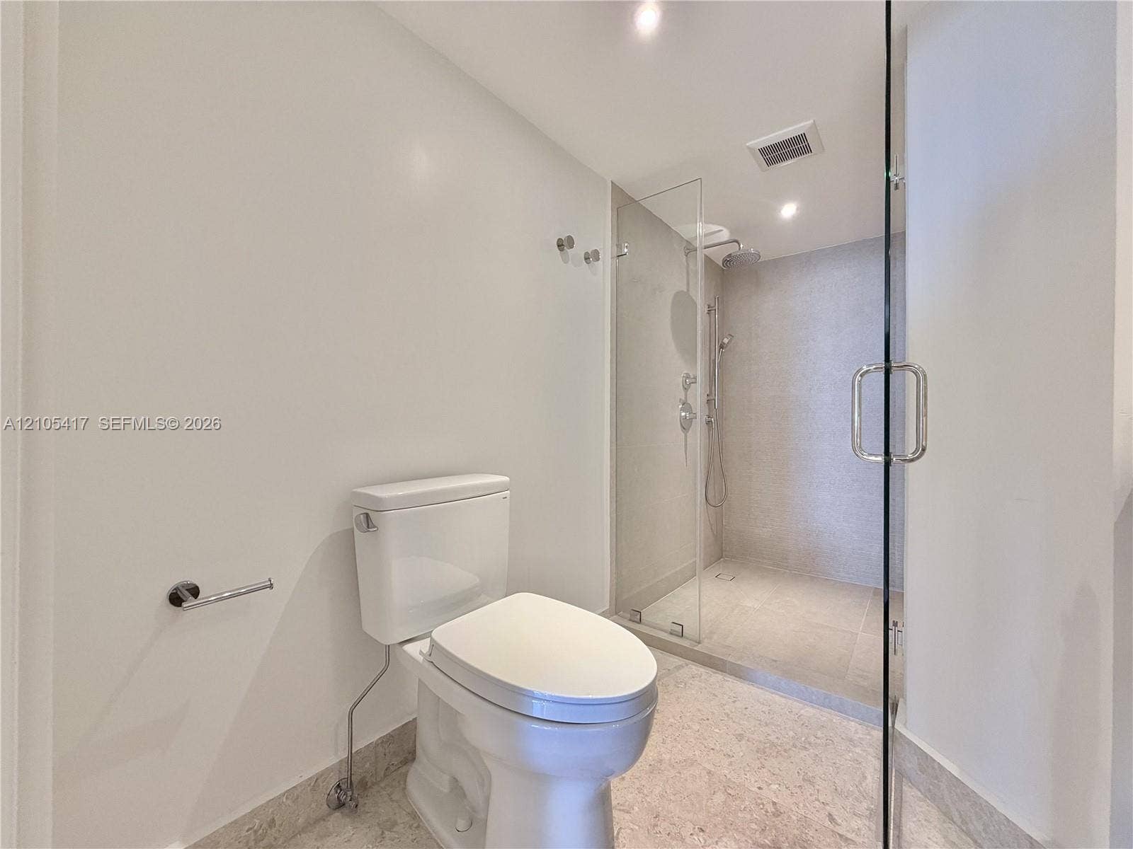 Full glass-enclosed shower with a rainfall showerhead, handheld shower fixture, and polished chrome hardware