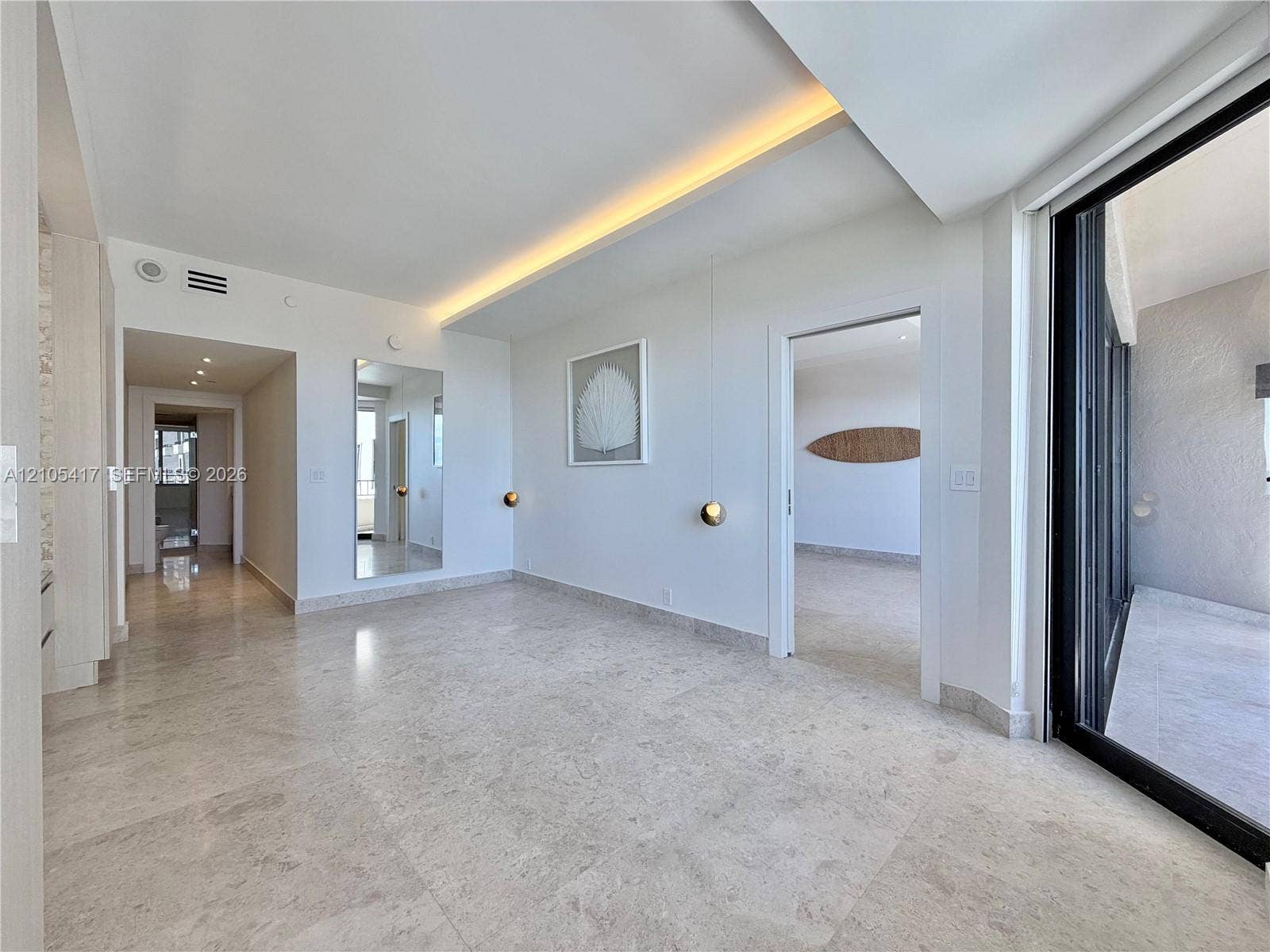 Polished tile flooring throughout, recessed ceiling lighting, a sliding glass door to exterior, and a hallway featuring additional recessed lighting