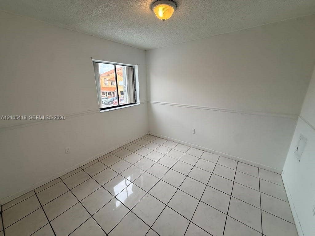 Recessed window, white tile flooring, white walls with chair rail molding, and a flush mount ceiling light