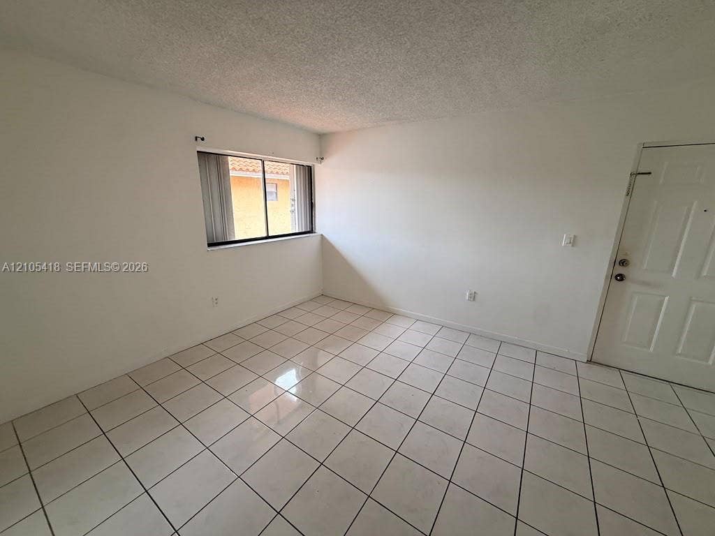 White tile flooring and a textured ceiling