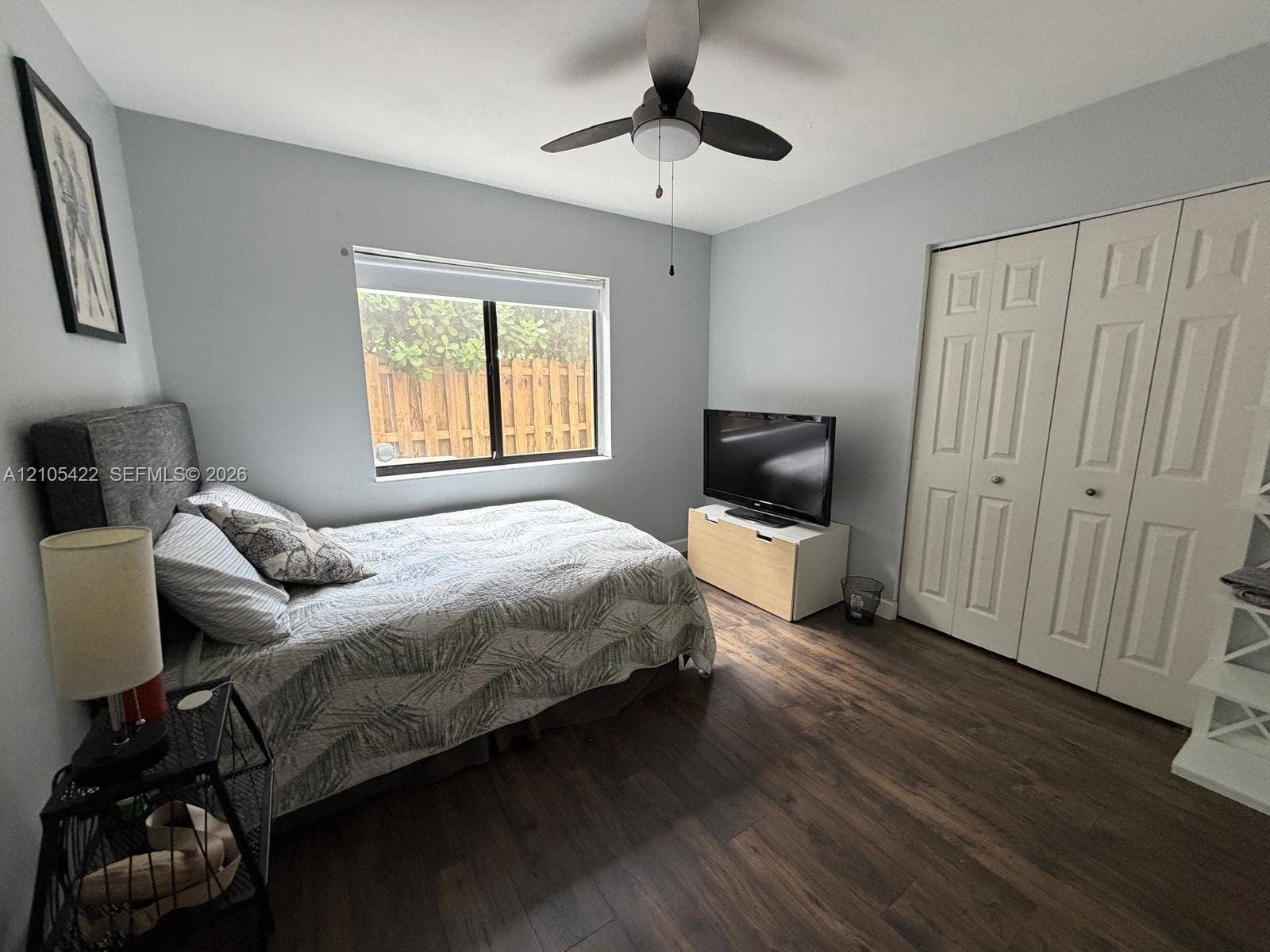 14631 SW 150th Street, Miami, FL 33186 Room featuring wood-finish flooring, dual-panel closet doors, and a ceiling fan with integrated lighting