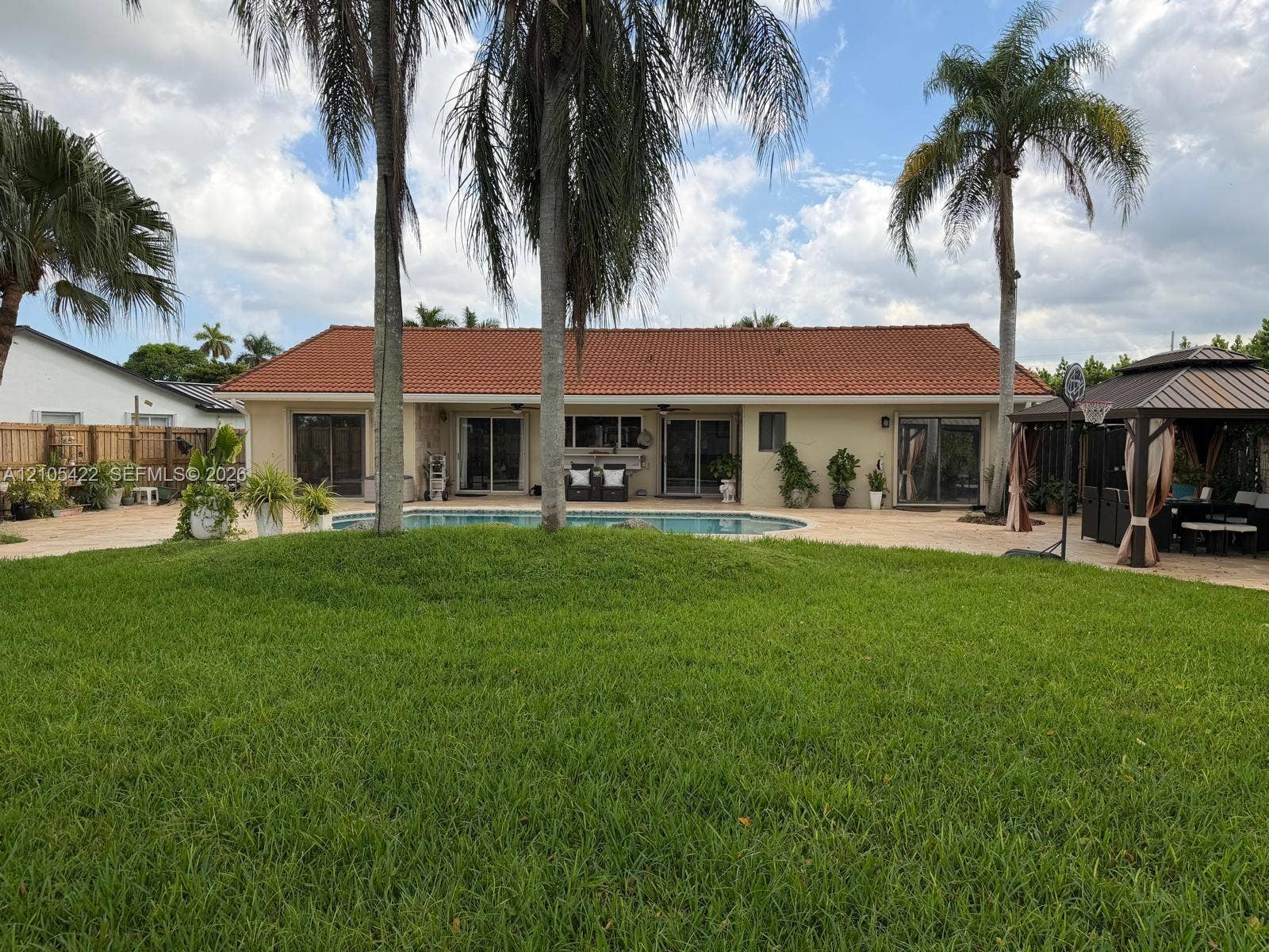 14631 SW 150th Street, Miami, FL 33186 Expansive backyard featuring a large swimming pool, paver patio, permanent gazebo structure, and mature palm trees