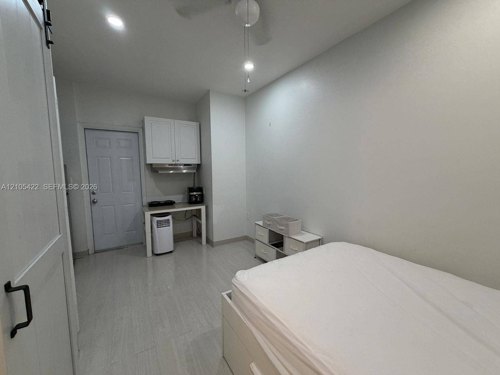 14631 SW 150th Street, Miami, FL 33186 Neutral-toned tile flooring, white shaker-style cabinetry, stainless steel range hood, and a modern ceiling fan with integrated lighting