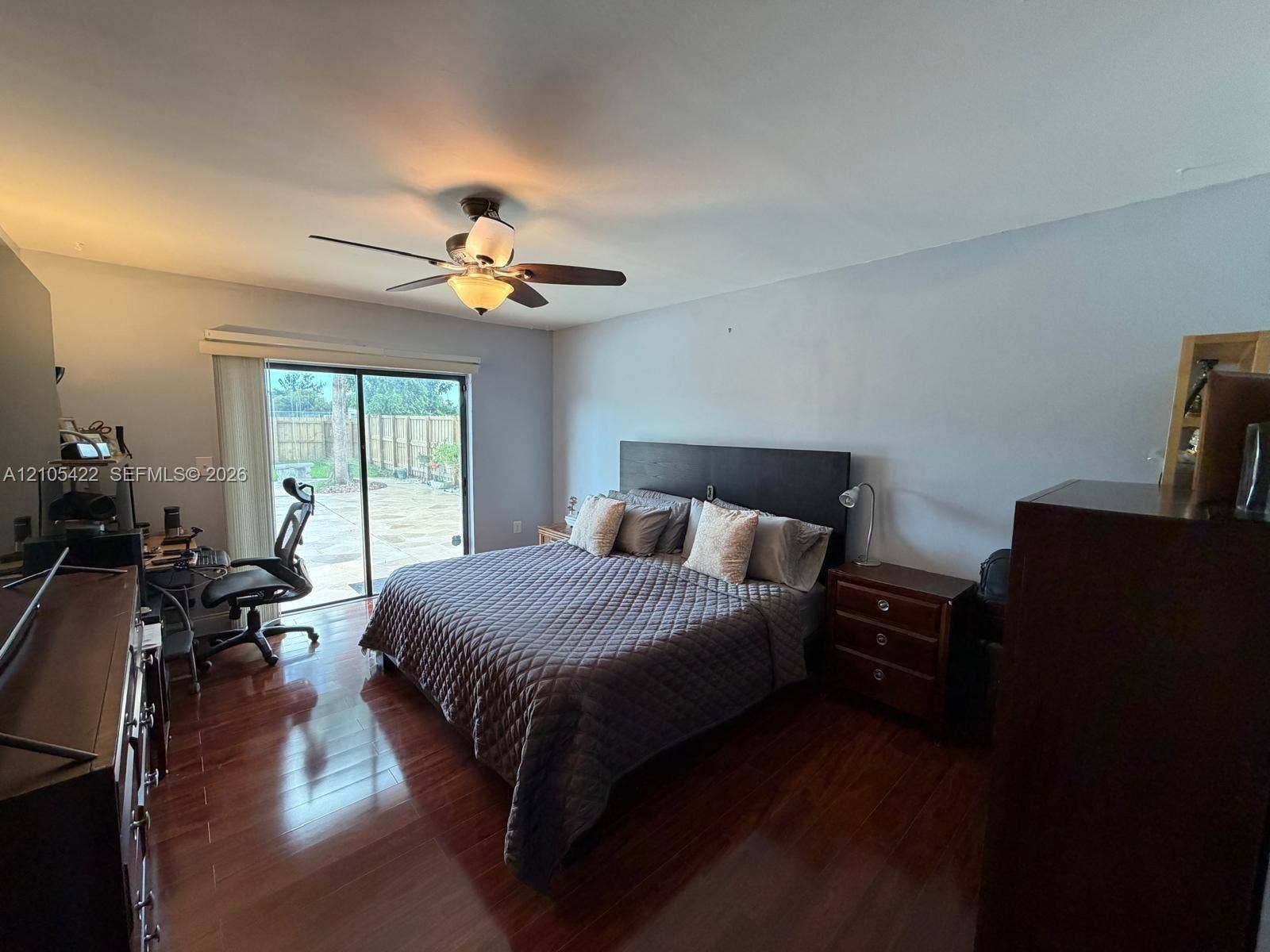14631 SW 150th Street, Miami, FL 33186 Room featuring wood-finish flooring, a ceiling fan with integrated lighting, and a sliding glass door providing external access
