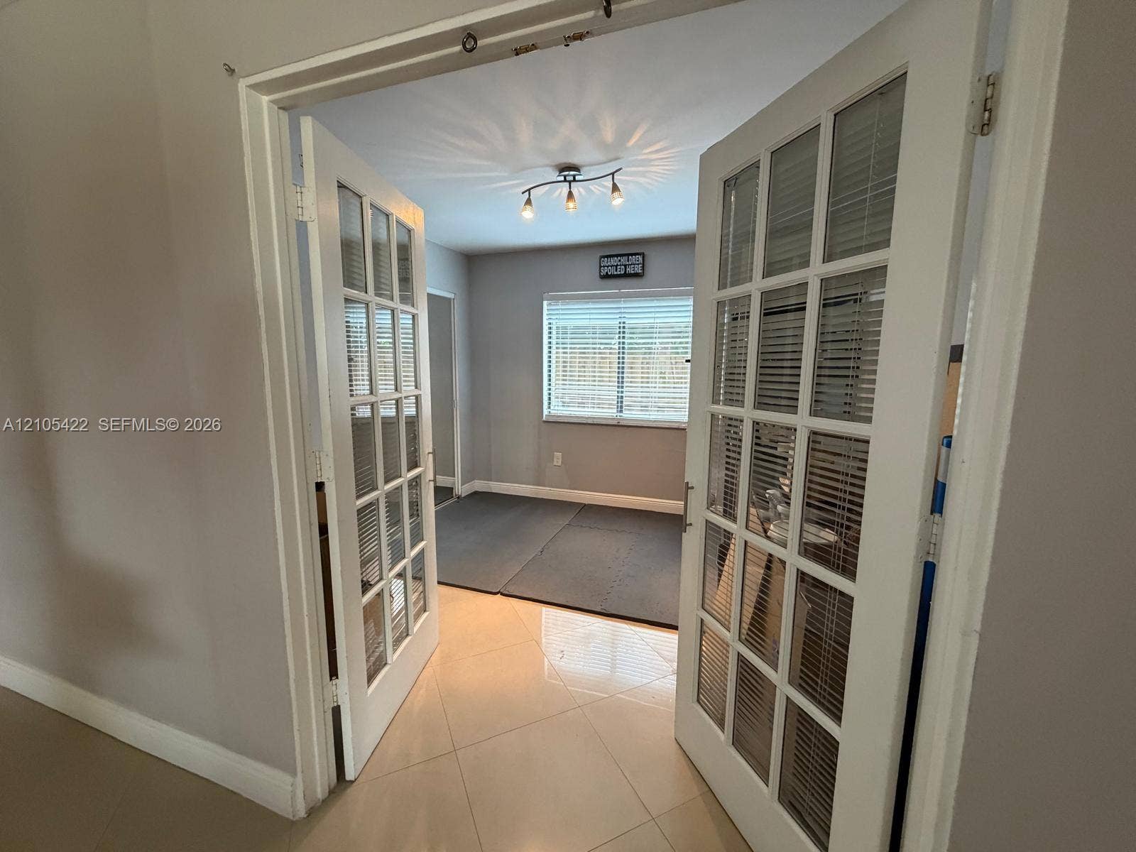 14631 SW 150th Street, Miami, FL 33186 Double French doors featuring multi-pane glass inserts, ceramic tile flooring, and a multi-bulb track lighting fixture