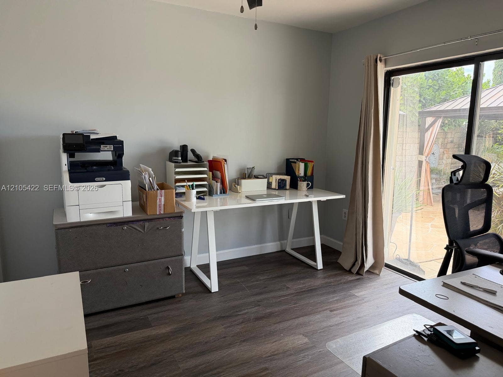 14631 SW 150th Street, Miami, FL 33186 Room featuring wood-finish flooring and a sliding glass door providing access to an outdoor patio