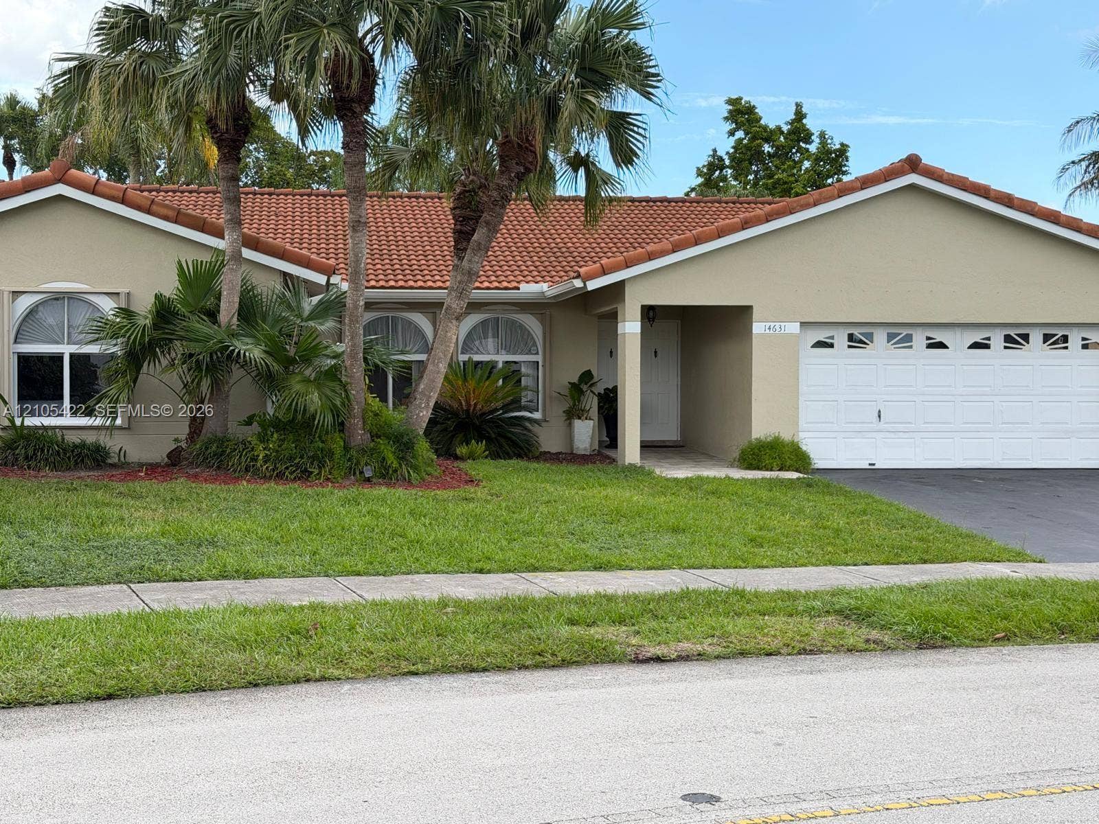 14631 SW 150th Street, Miami, FL 33186 Single-story exterior featuring a clay tile roof, arched window accents, and a two-car garage