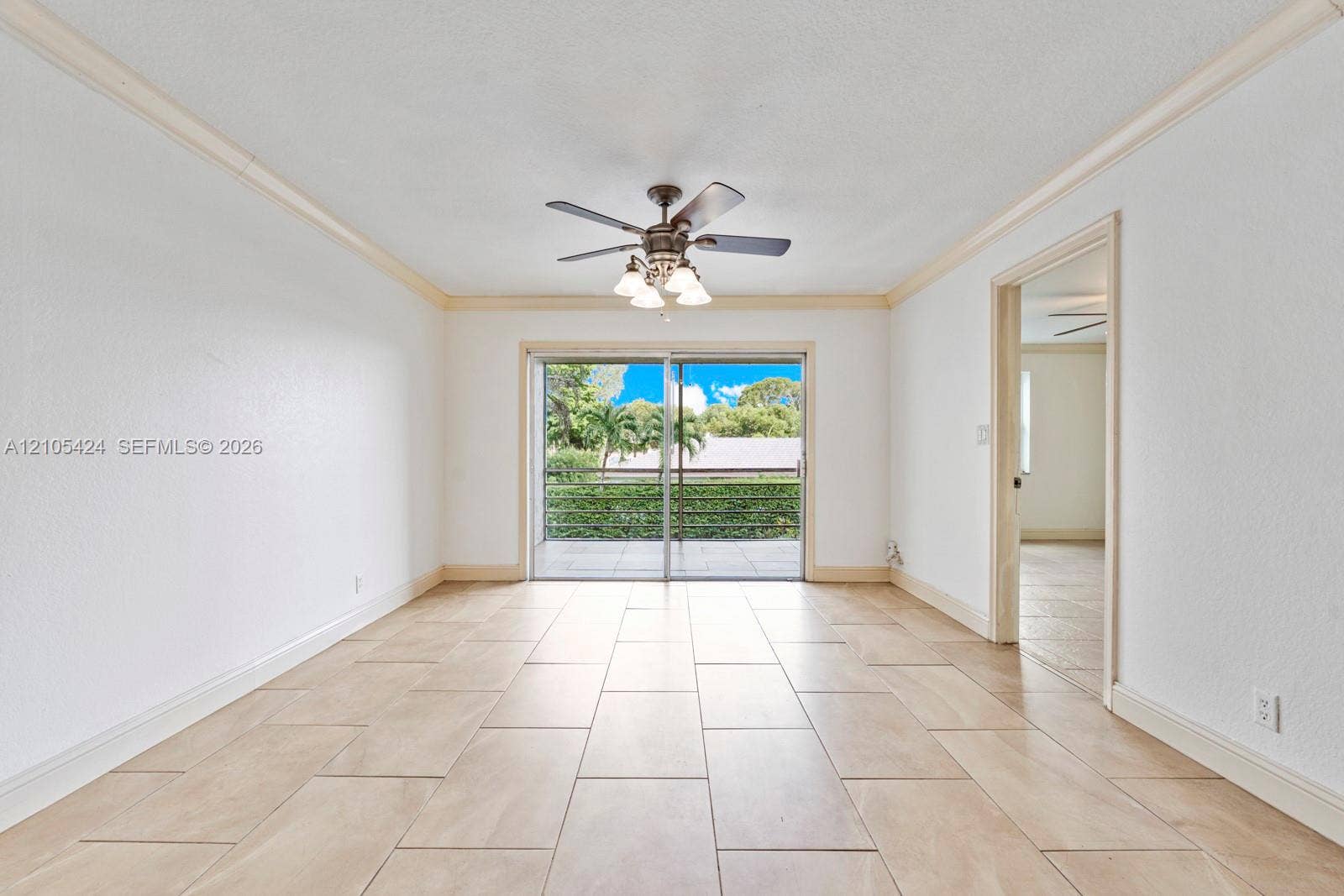 Tile flooring throughout, crown molding, and direct access to an outdoor patio space