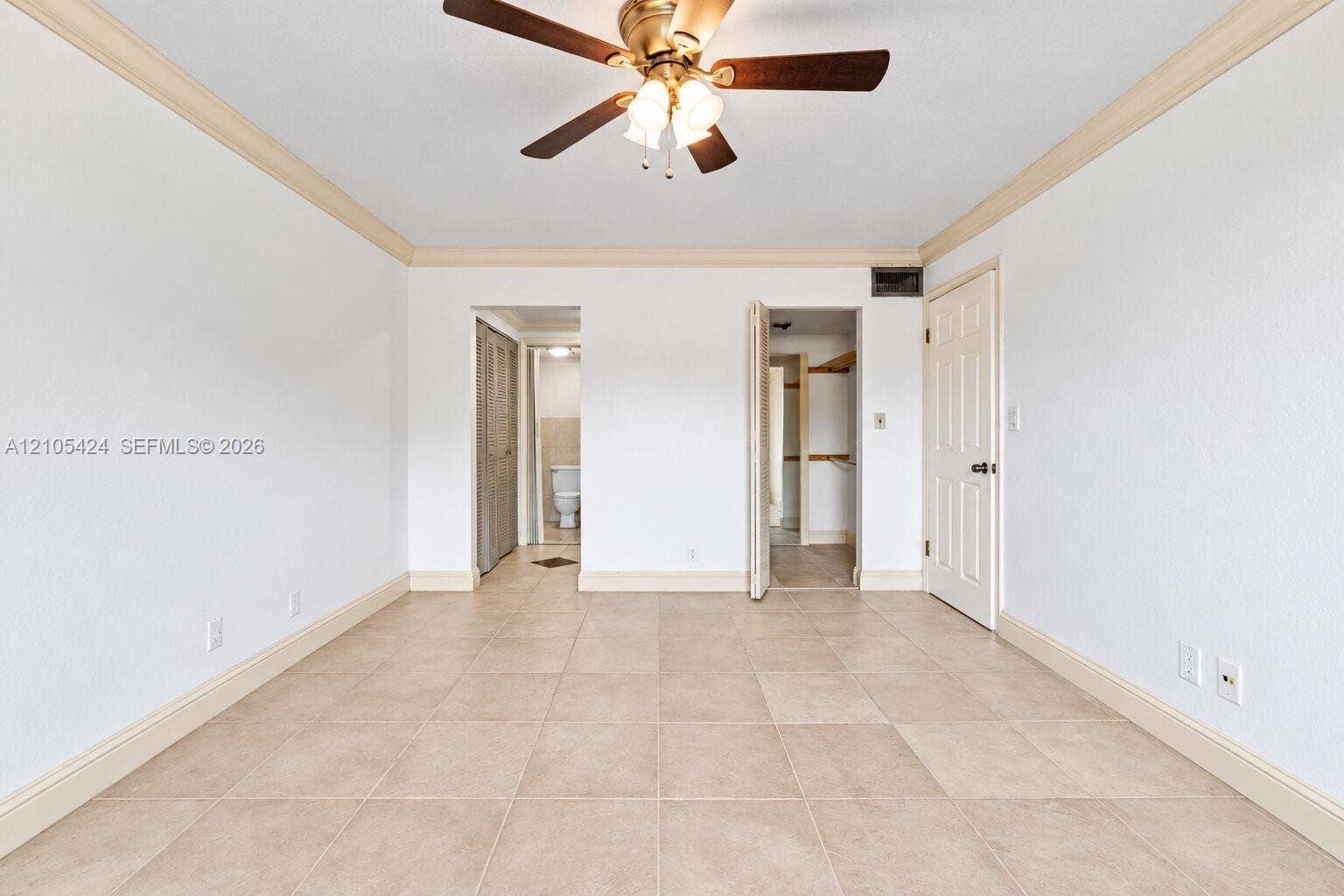 Recessed ceiling fan with wood-finish blades, crown molding, tile flooring, and white paneled doors