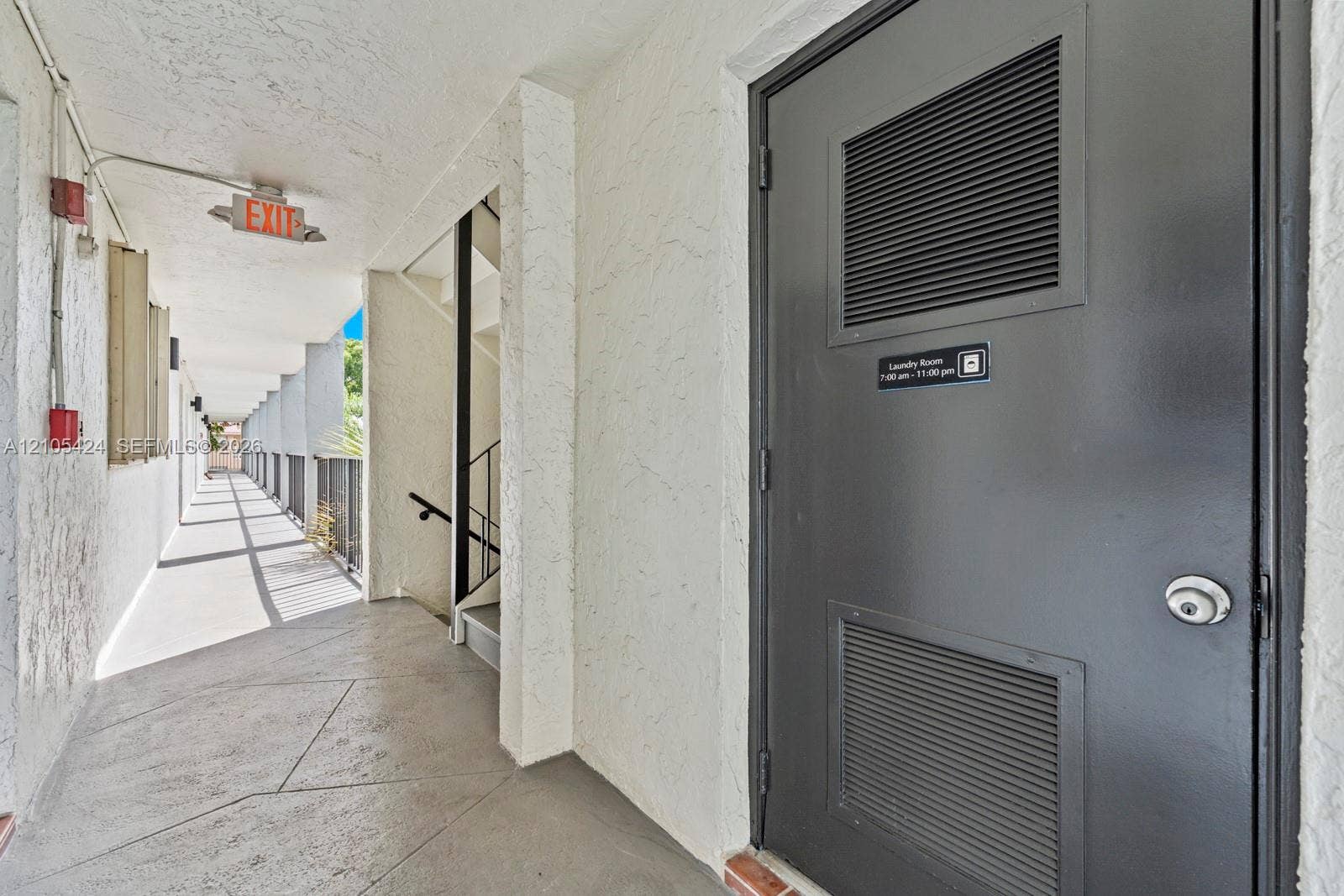 Laundry room access with a dark gray door featuring louvered panels