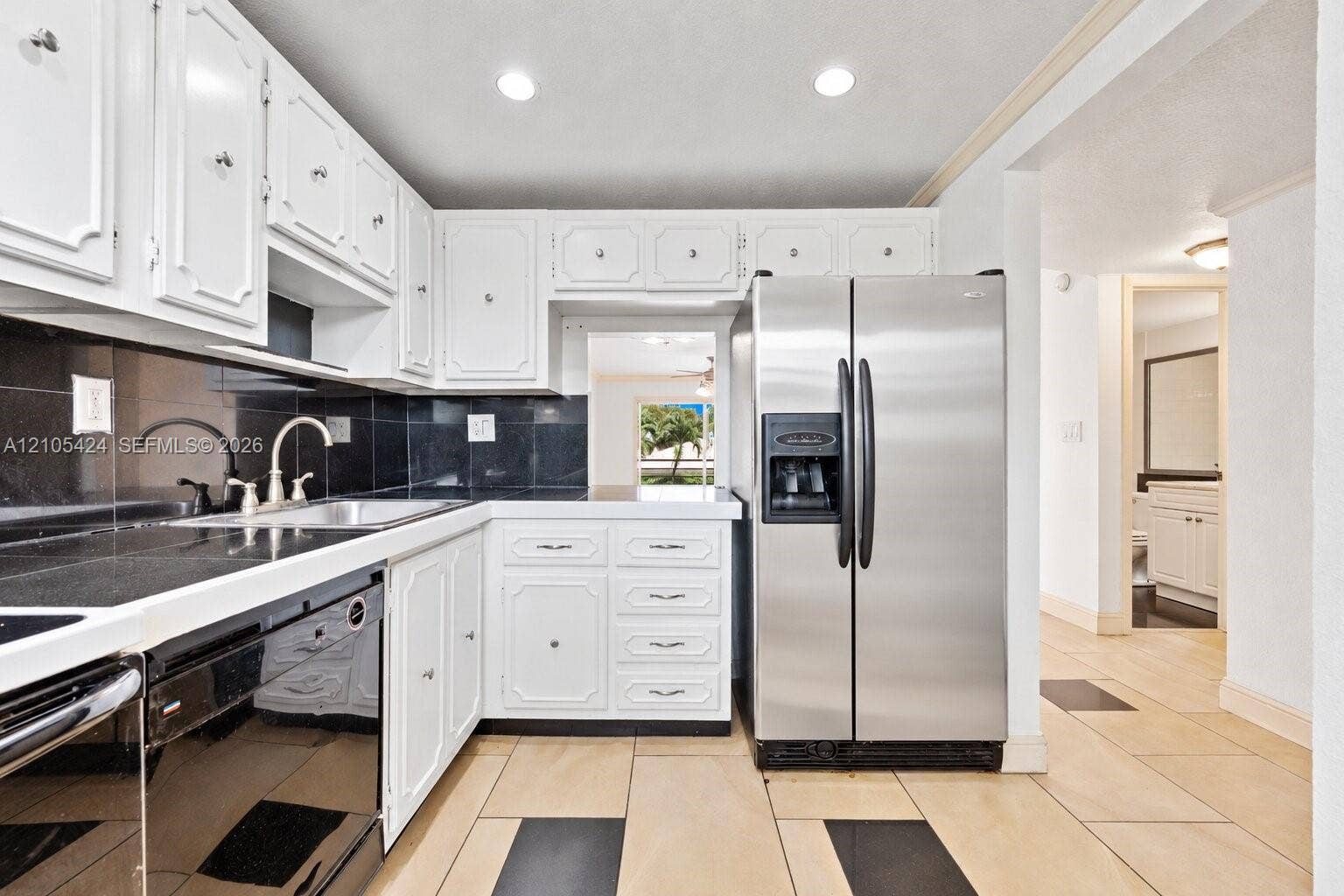 White cabinetry paired with dark countertops and a coordinating tile backsplash