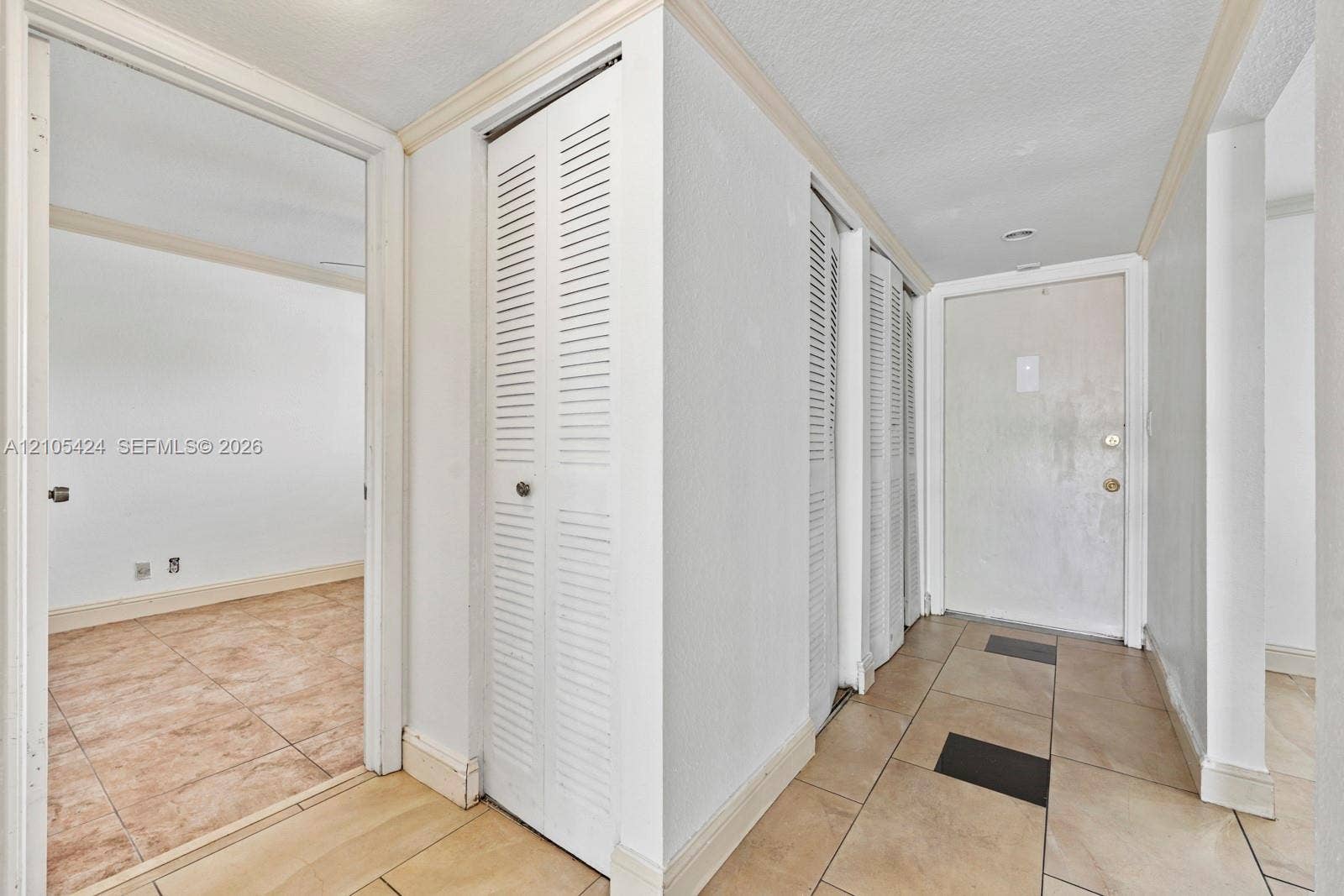 Entryway featuring tile flooring, louvered bi-fold doors, and a solid entry door