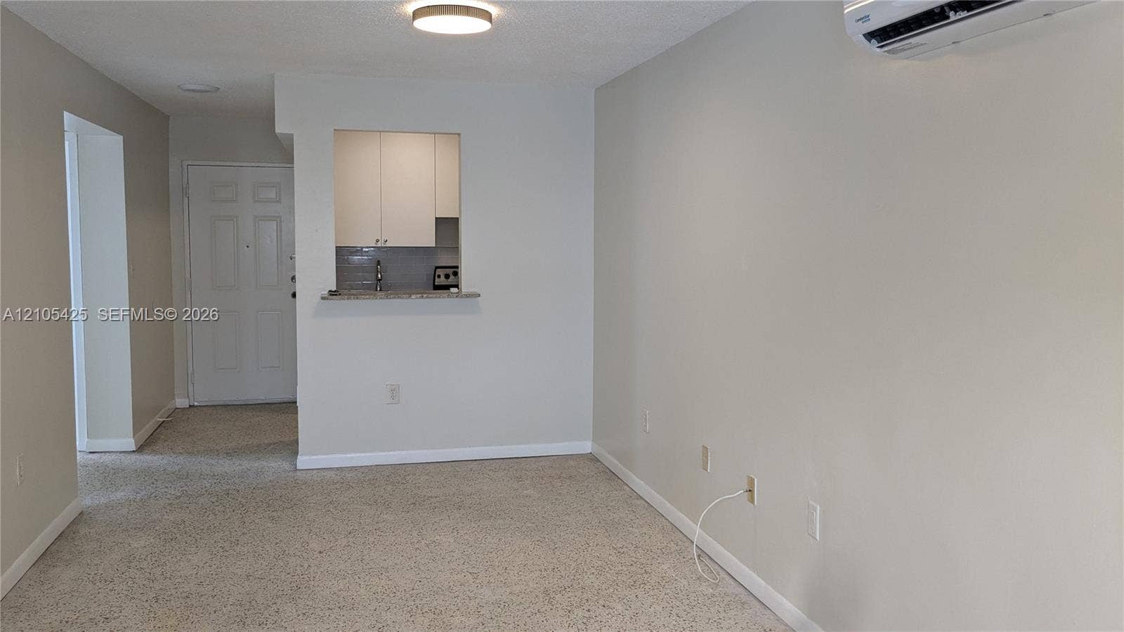 Recessed kitchen pass-through with light-toned cabinetry and grey tiled backsplash