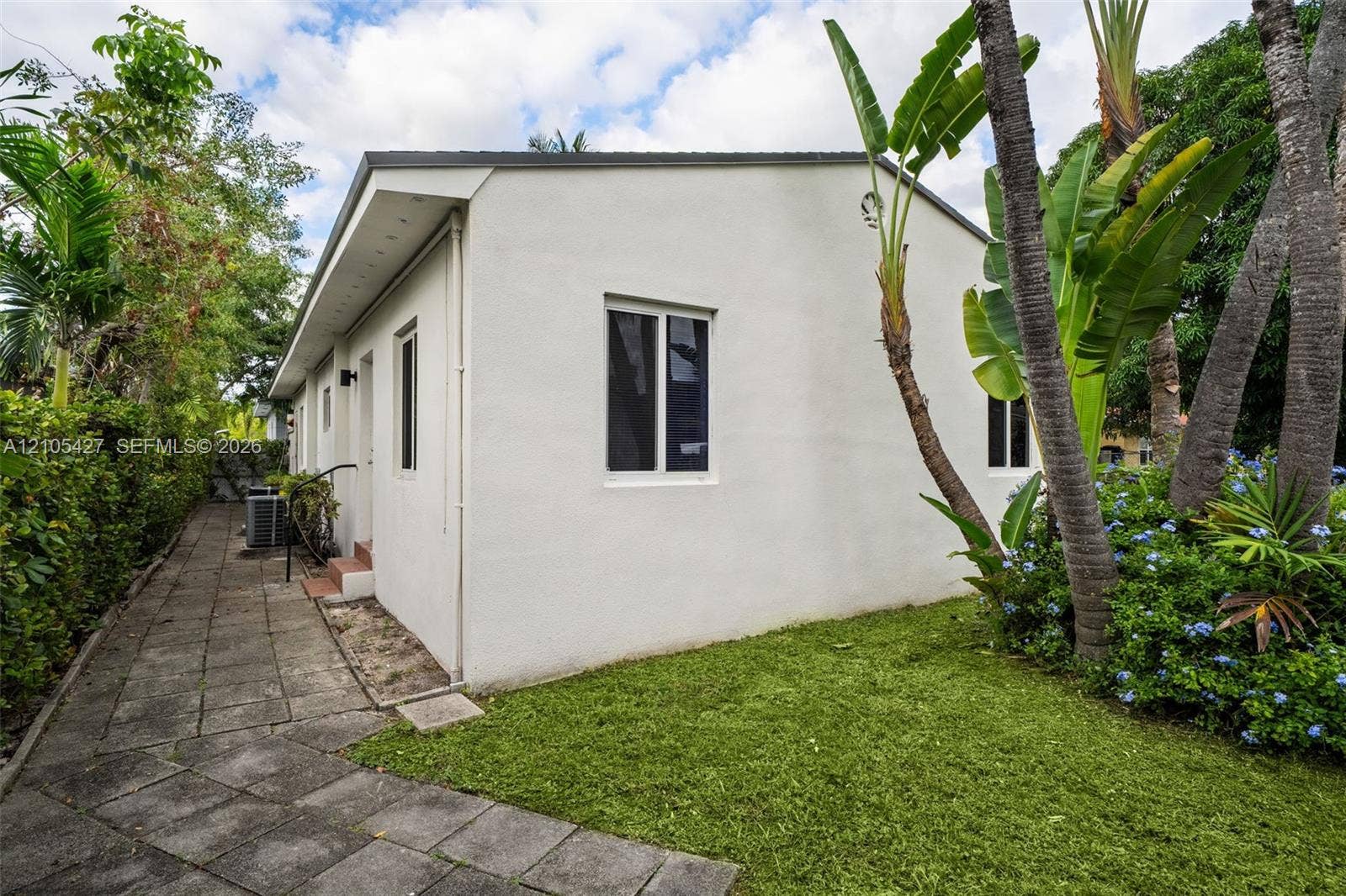 White stucco exterior with a dark roofline