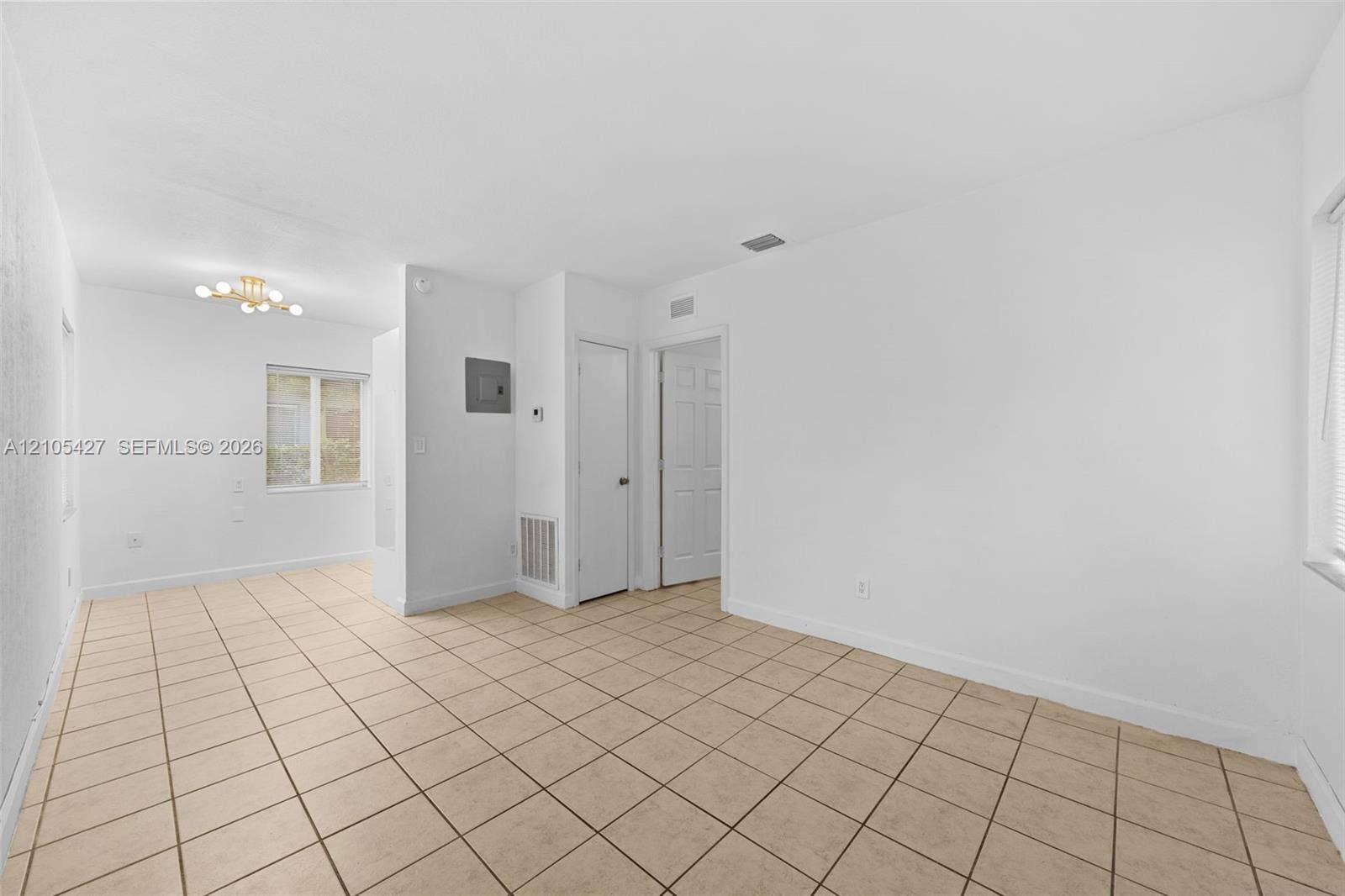 Expansive tile flooring, bright white walls, and a recessed ceiling light fixture