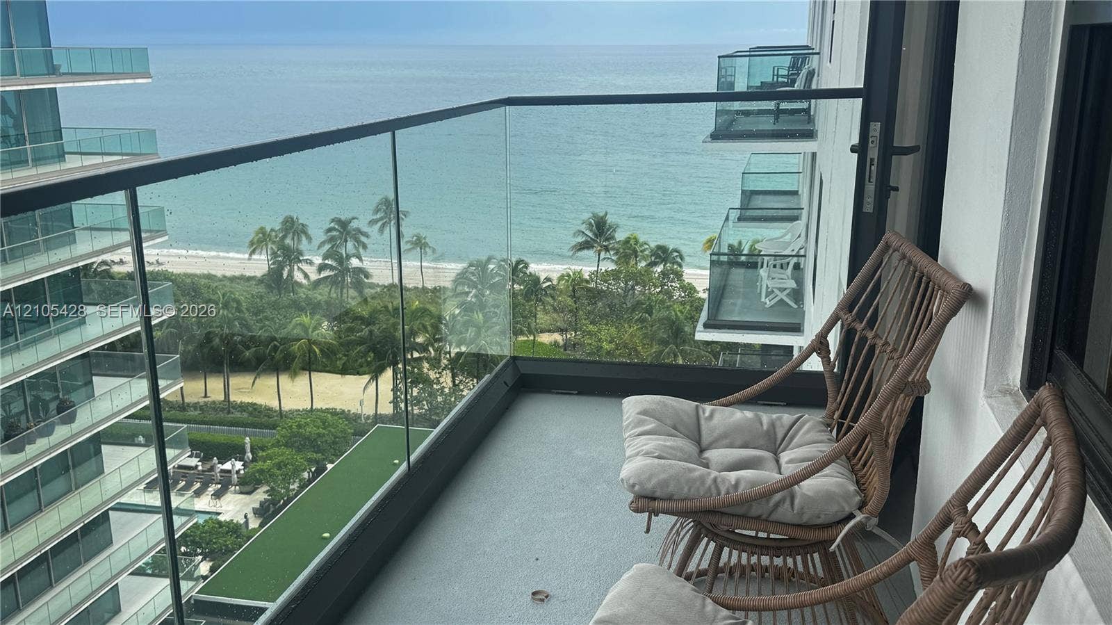 Expansive balcony with glass panel railing and ocean scenery