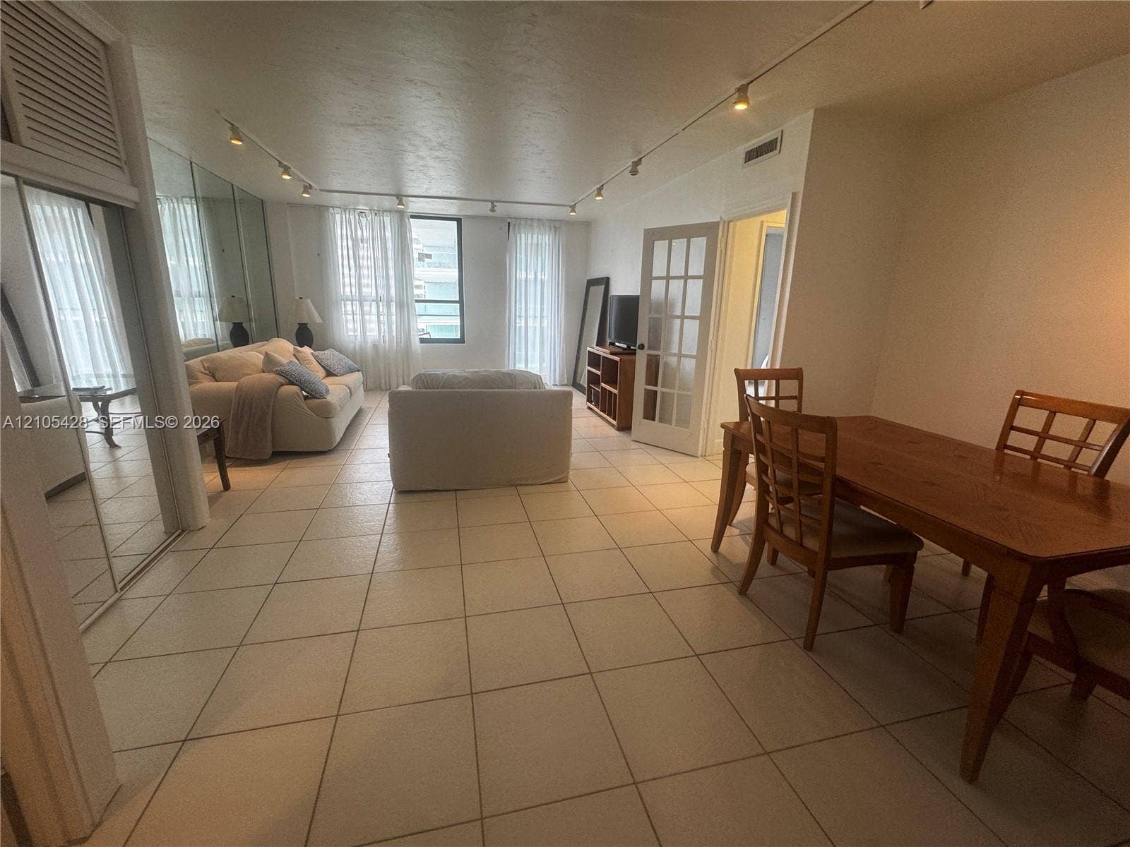Tile flooring throughout, track lighting, and French doors