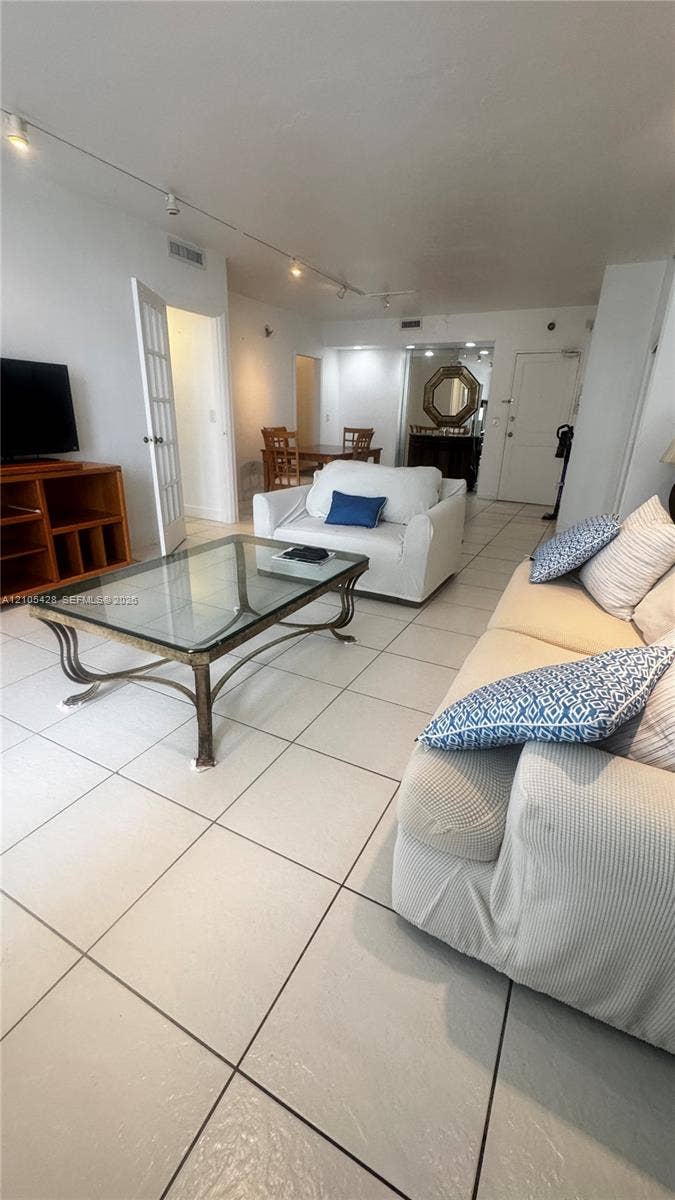 Tile flooring throughout, track lighting, and a built-in media console