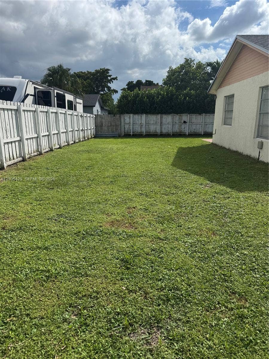 Fenced yard featuring a green lawn