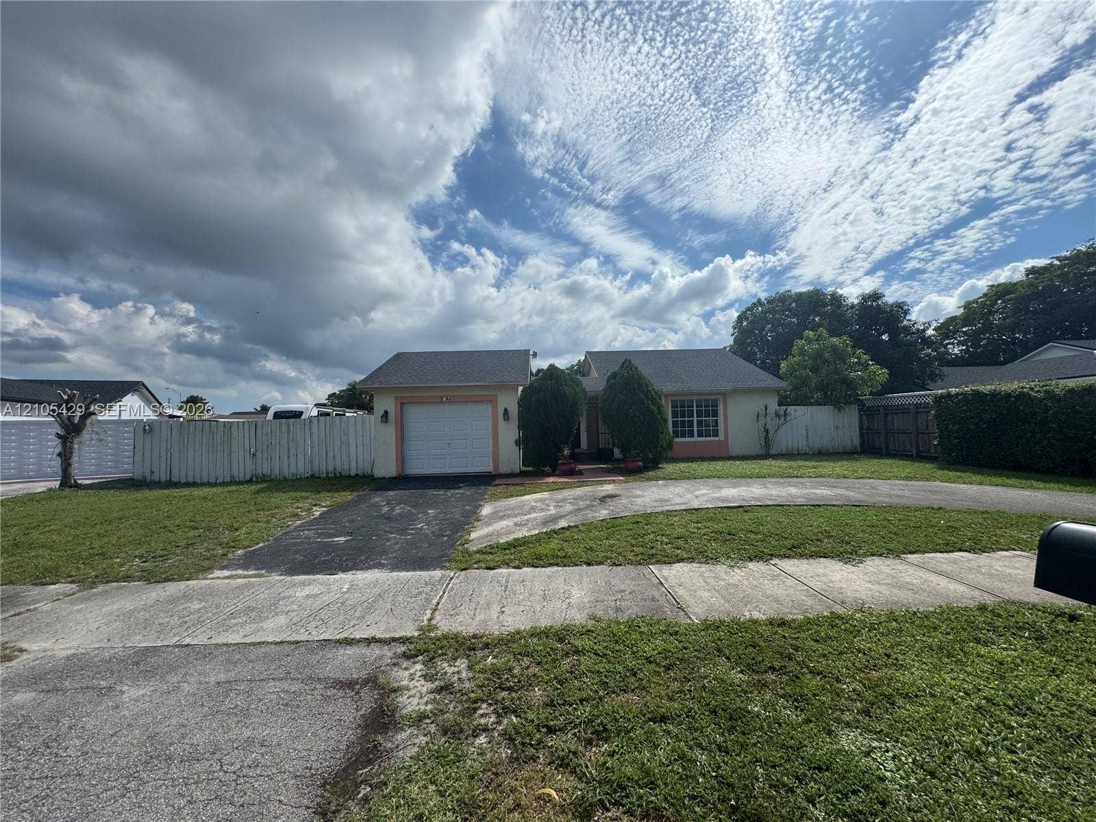Single-story residence featuring an attached garage and a circular driveway