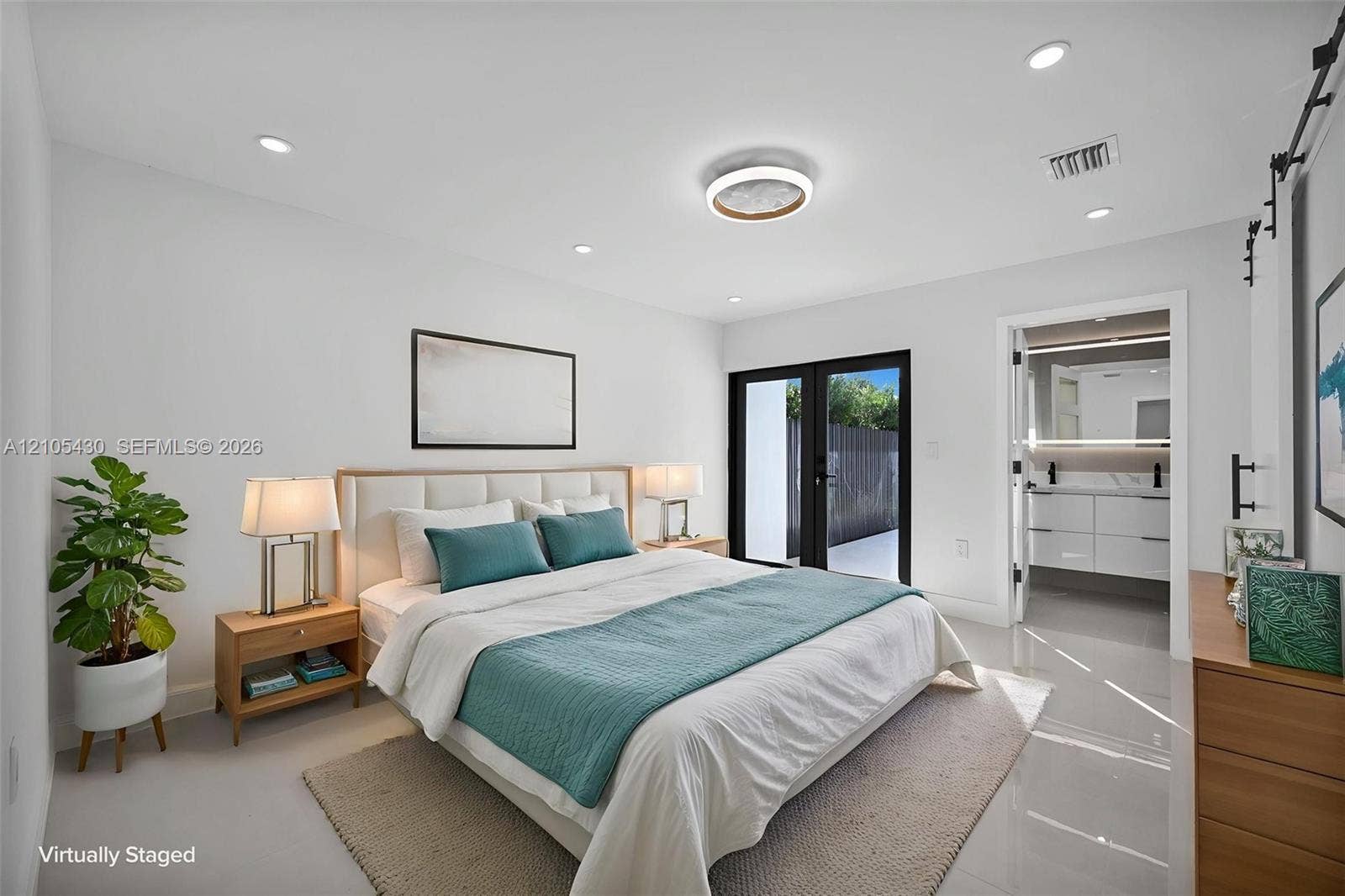 Interior space featuring neutral tile flooring, recessed lighting, a modern circular flush-mount ceiling fixture, glass-paned double doors, and a doorway showcasing a multi-drawer vanity