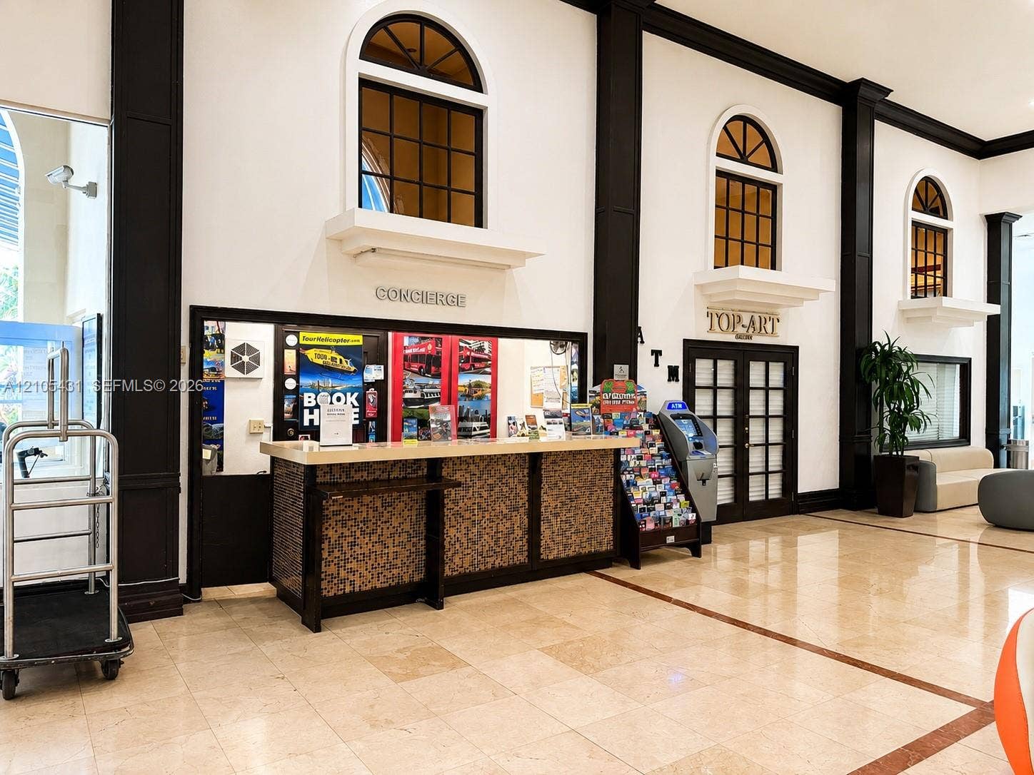19201 Collins Avenue, #707, Sunny Isles Beach, FL 33160 Tiled flooring with contrasting border accents, reception desk with textured paneling, and arched upper-level windows