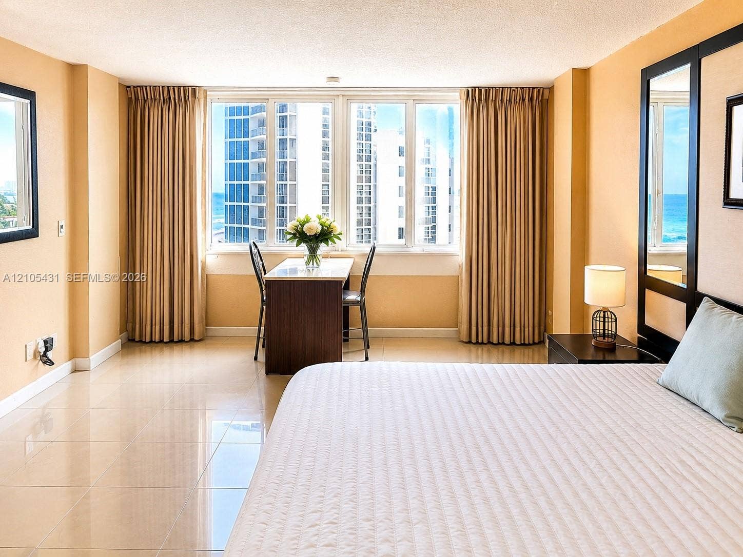 19201 Collins Avenue, #707, Sunny Isles Beach, FL 33160 Expansive window wall, tiled flooring, built-in desk, and full-length wall mirror