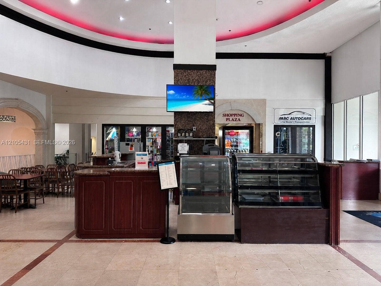 19201 Collins Avenue, #707, Sunny Isles Beach, FL 33160 Interior commercial space featuring tile flooring, a built-in wood-finish counter, and integrated display cases