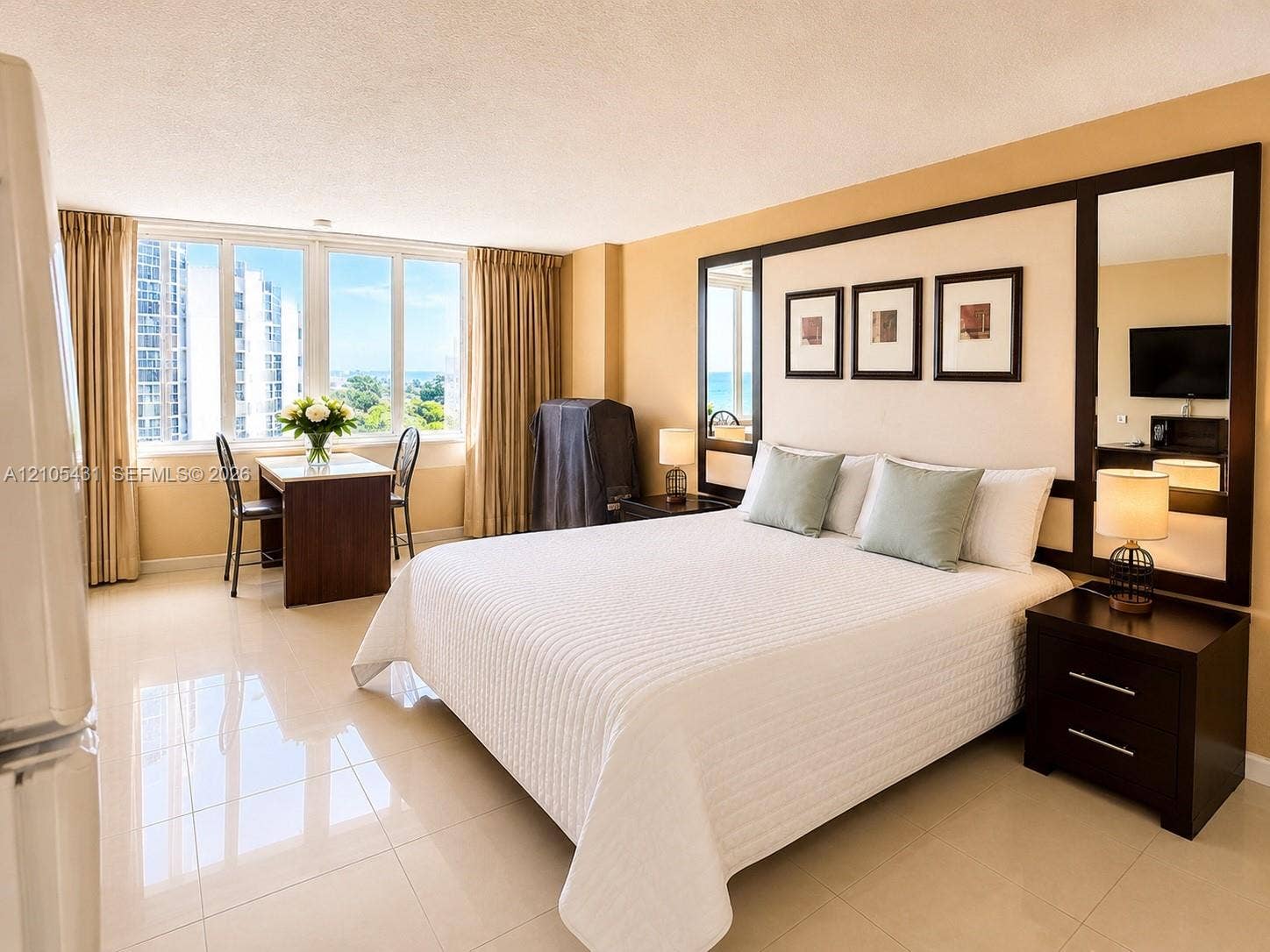 19201 Collins Avenue, #707, Sunny Isles Beach, FL 33160 Expansive window offering abundant natural light, large format tile flooring, built-in headboard wall feature, integrated mirrors, and recessed lighting