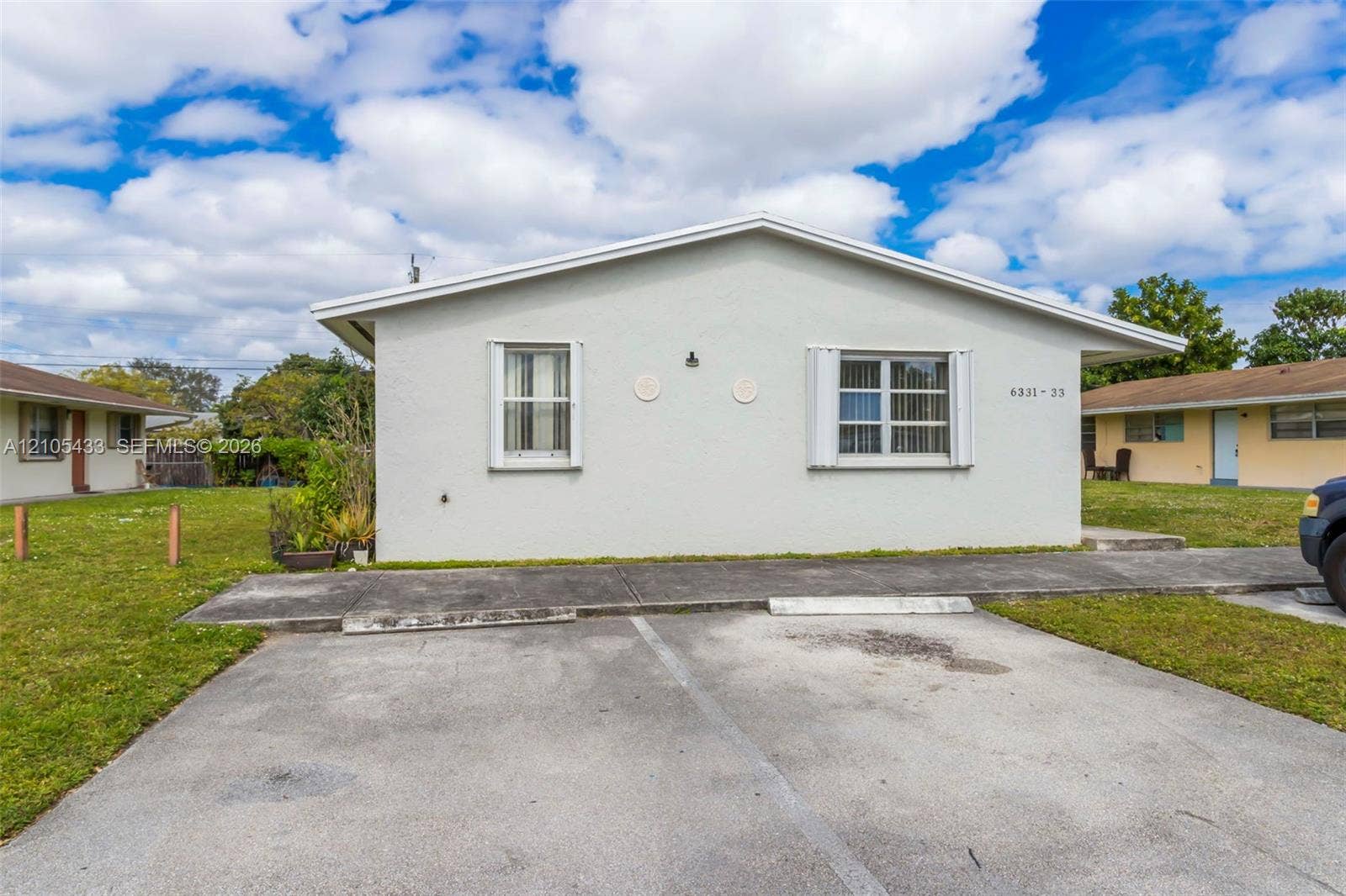 6331 Pierce Street, #1, Hollywood, Hollywood, FL 33024 Stucco exterior with white trim, multiple windows, and a paved parking area